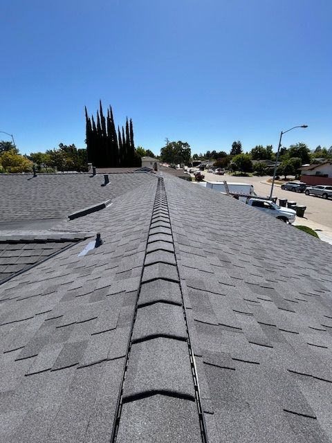 A roof with two chimneys on it and a blue sky in the background.