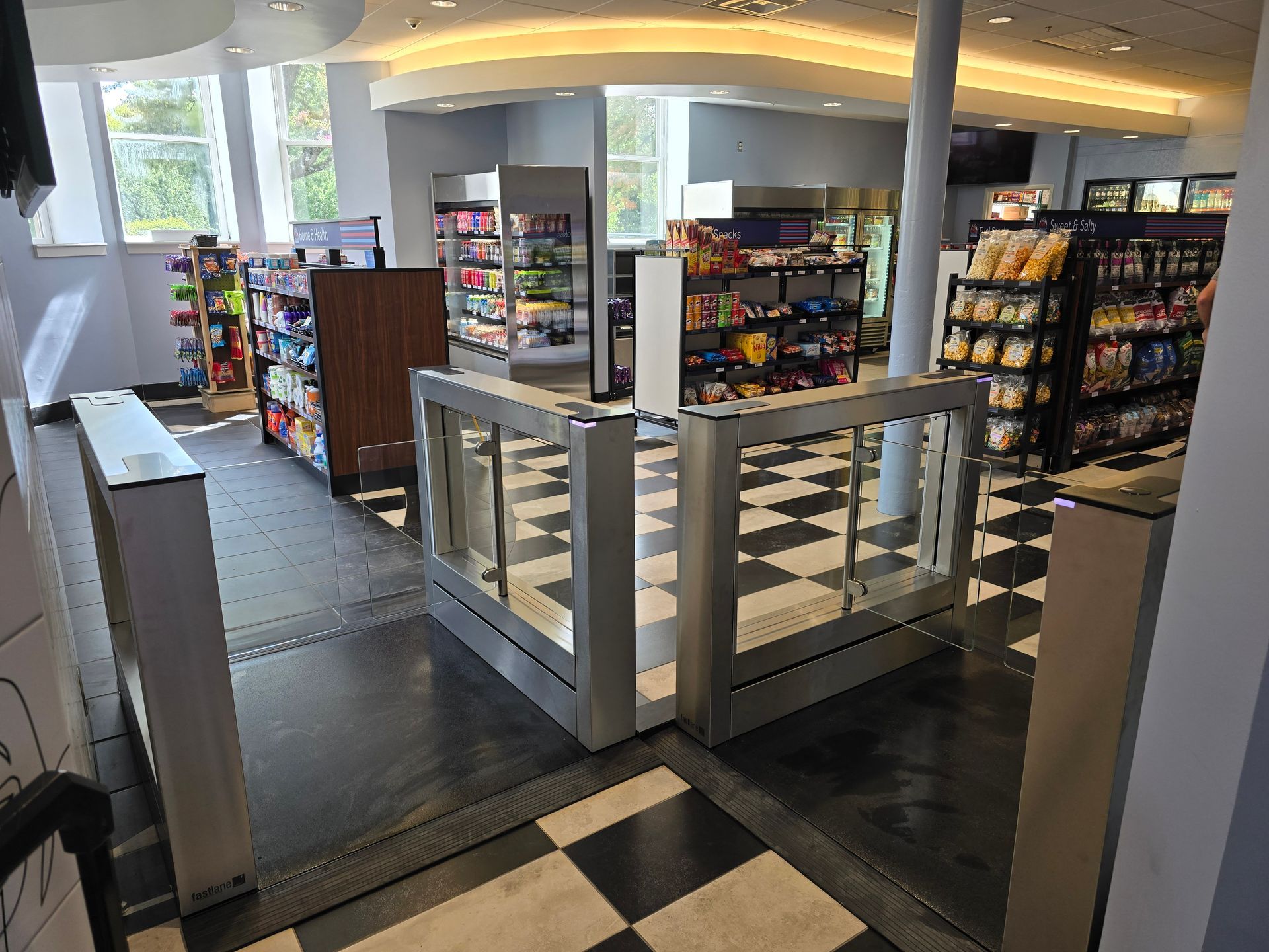 A convenience store interior with aisles of snacks and drinks. 
