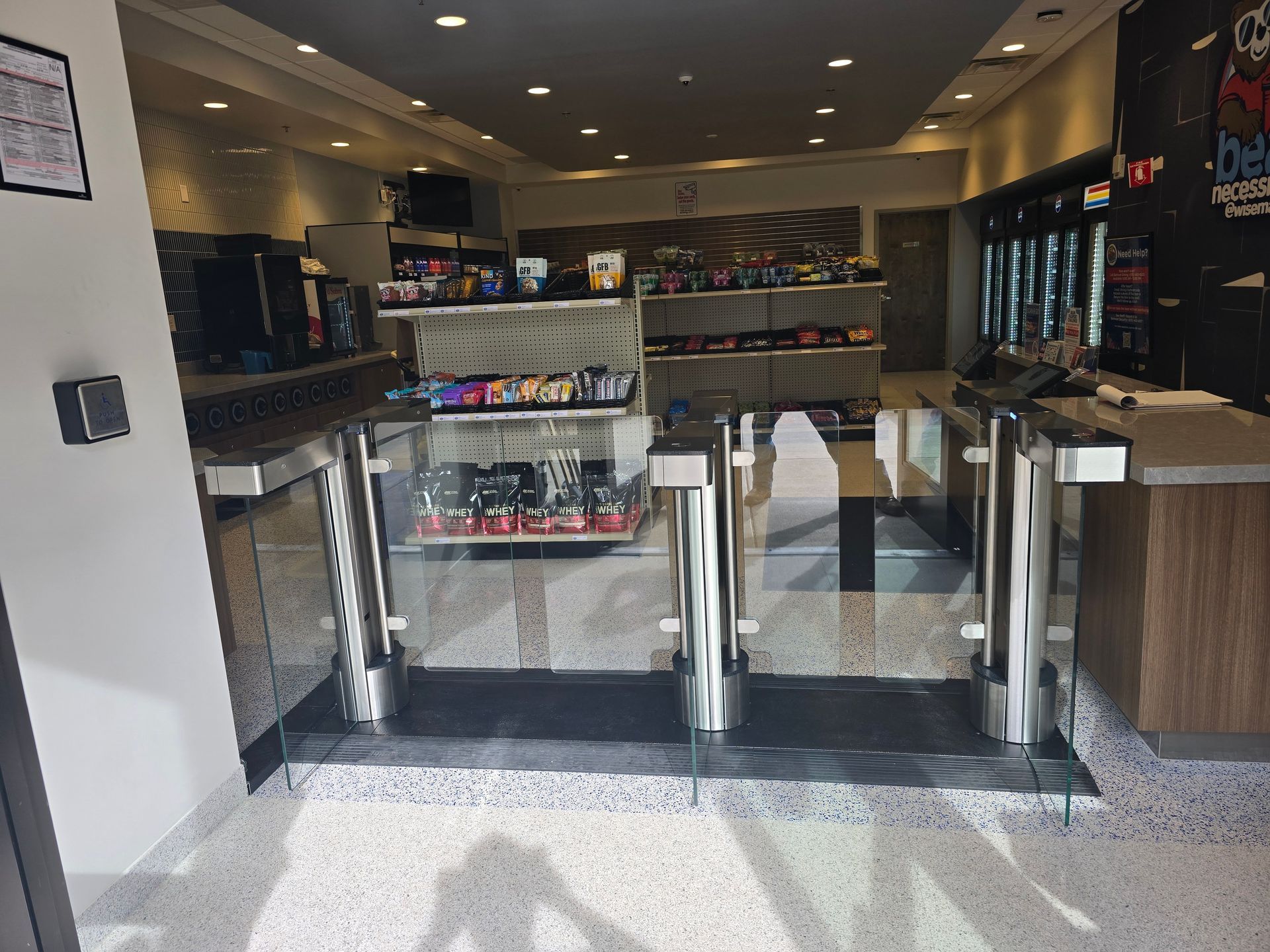 Entrance with turnstiles and snacks for sale inside a shop.