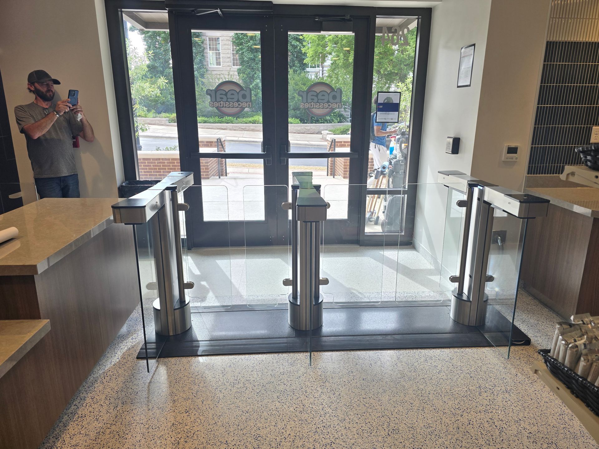 Turnstile entrance to building with glass panels. 