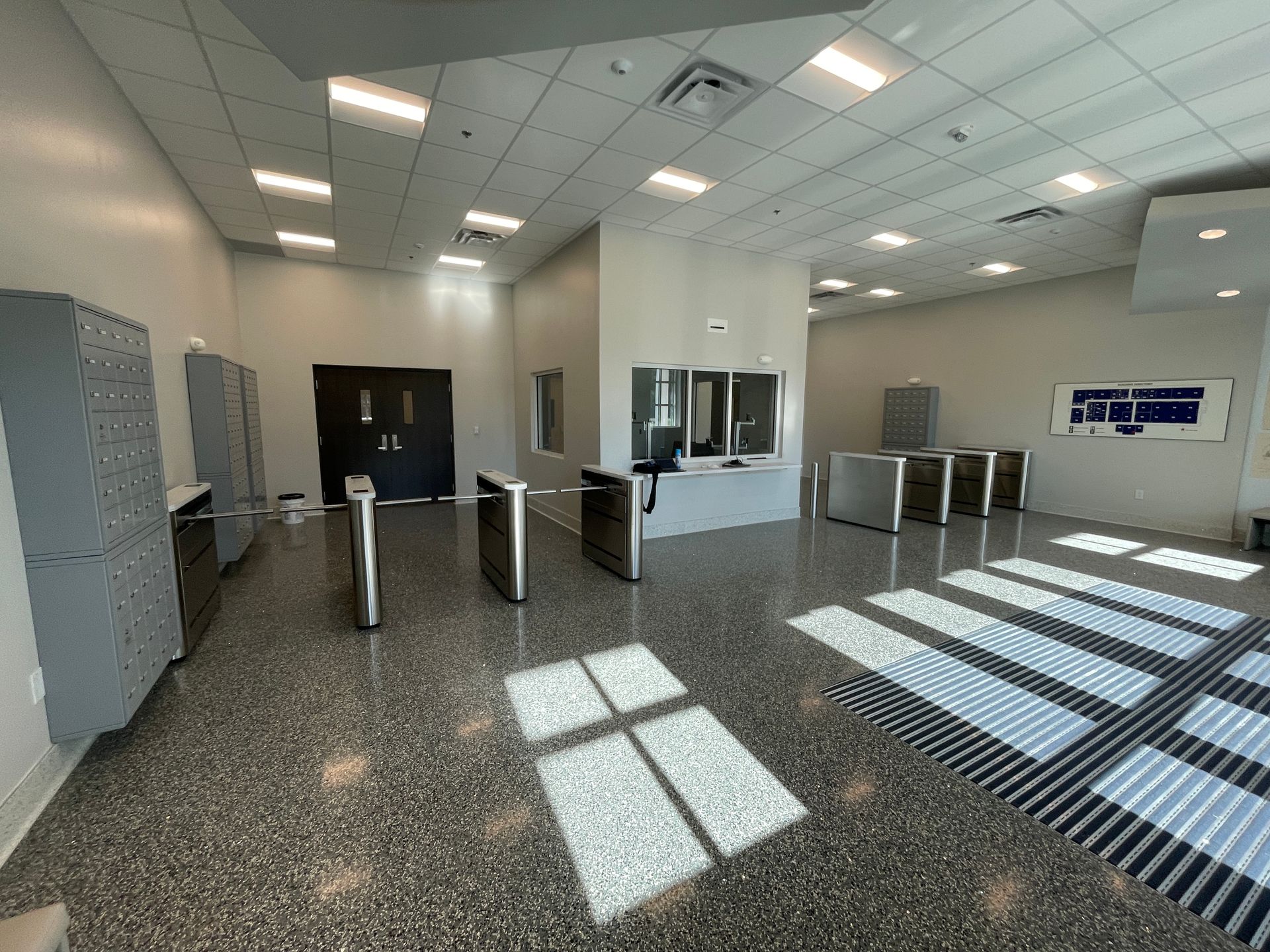 Lobby with turnstiles, lockers, and security desk. 