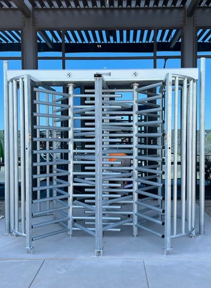 A large, metallic turnstile with multiple sections, likely for crowd control or access.
