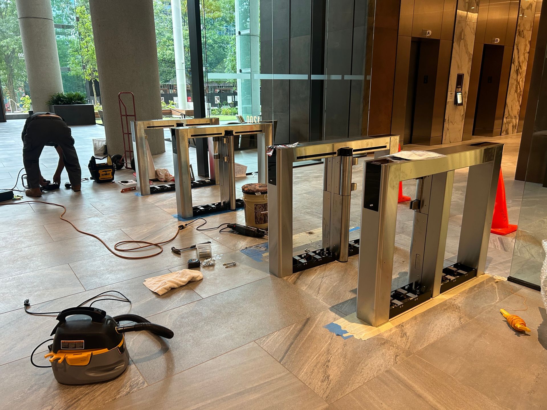 Turnstiles being installed in a lobby. 