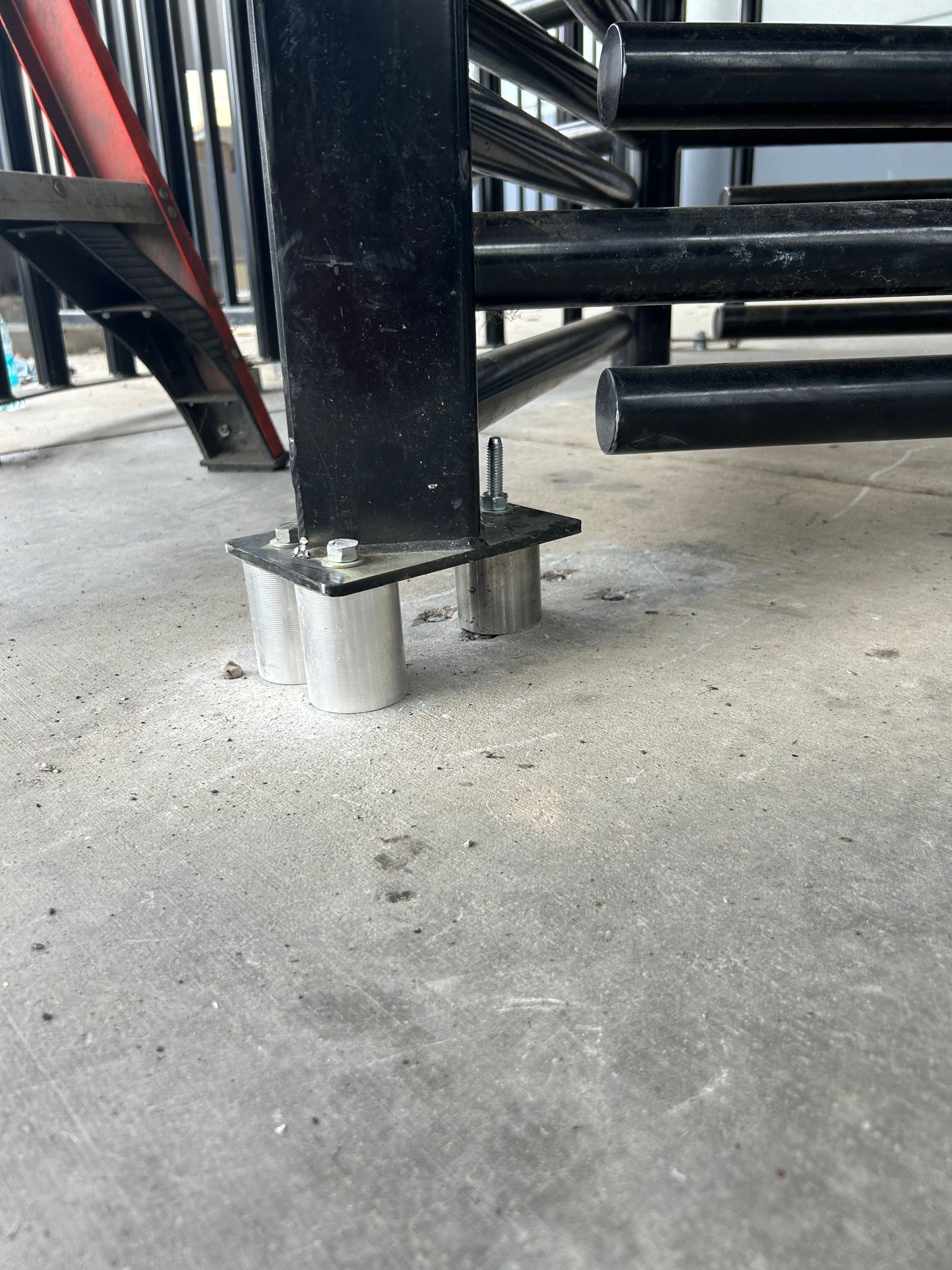 Black metal staircase base attached to a concrete surface.