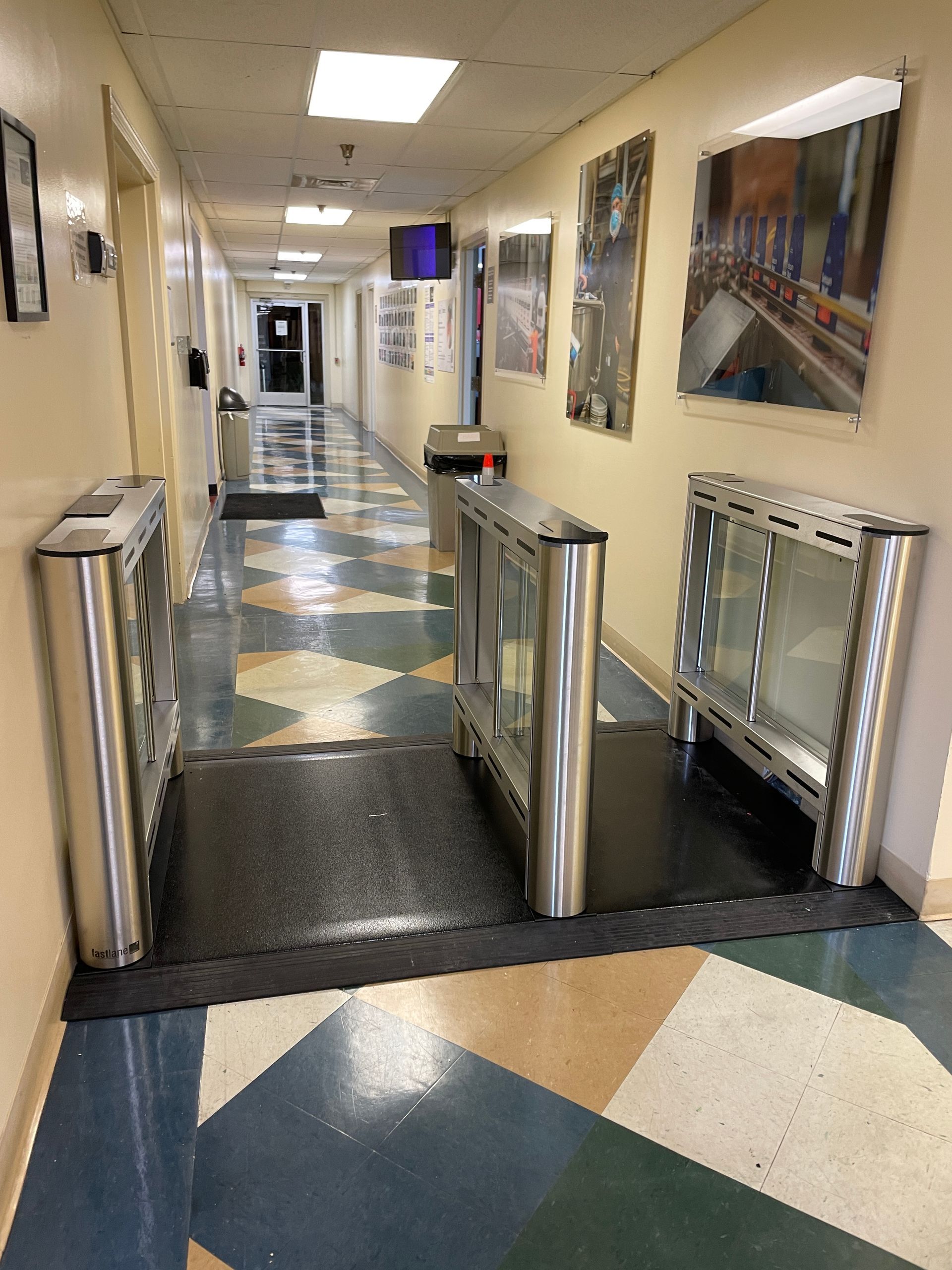 Hallway with security turnstiles and artwork on the wall. 