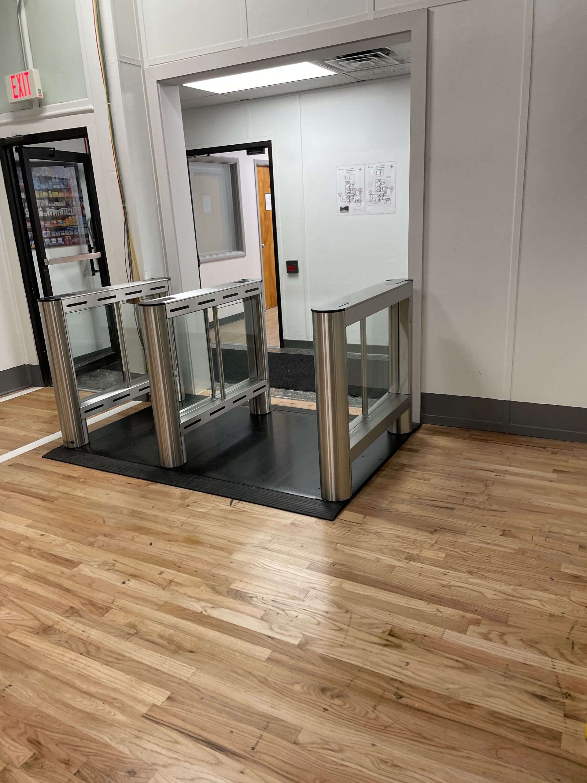 Metal wheelchair lift with glass panels installed in a doorway.  