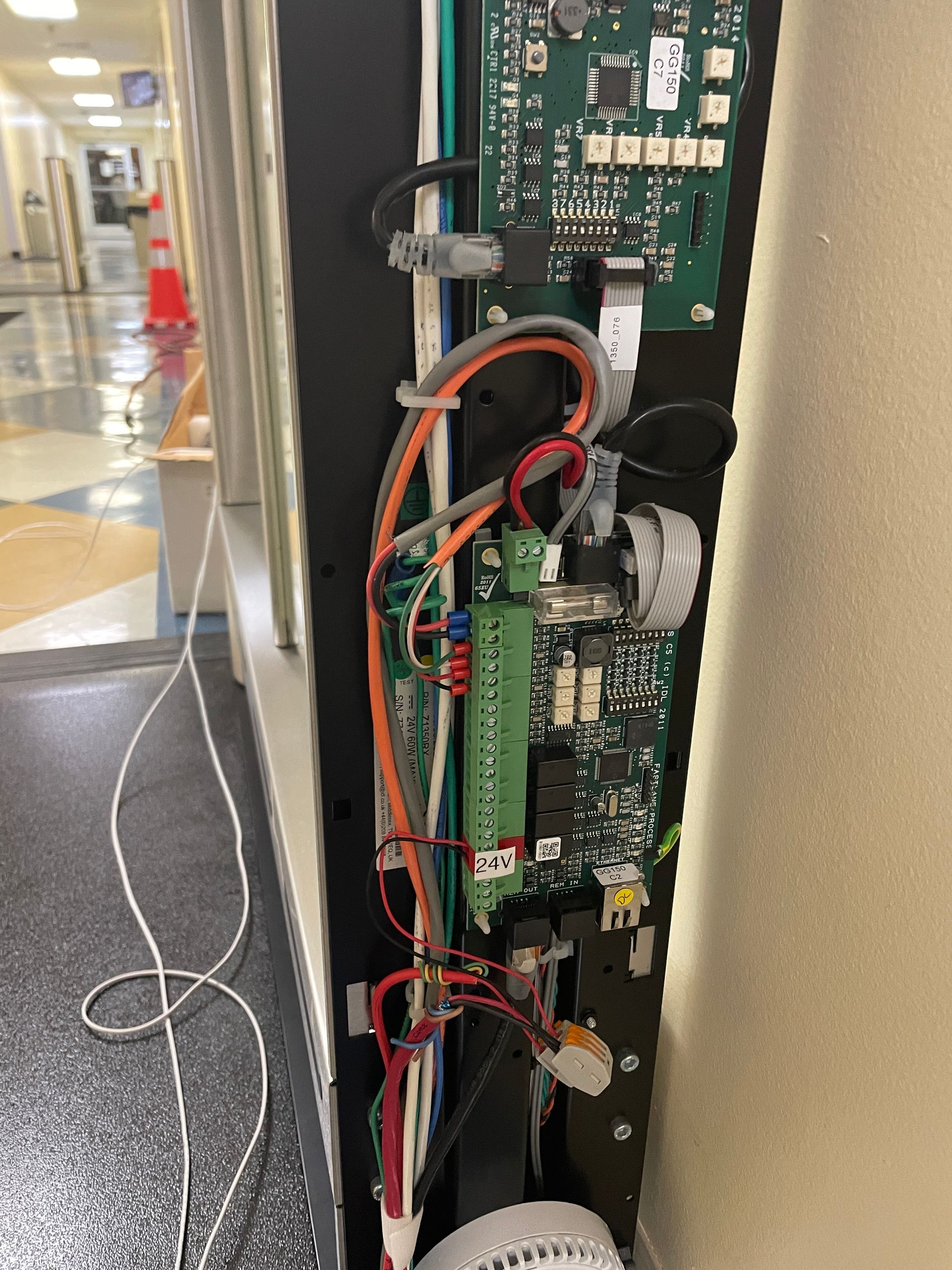 Open access panel revealing electronic circuit boards and wiring.