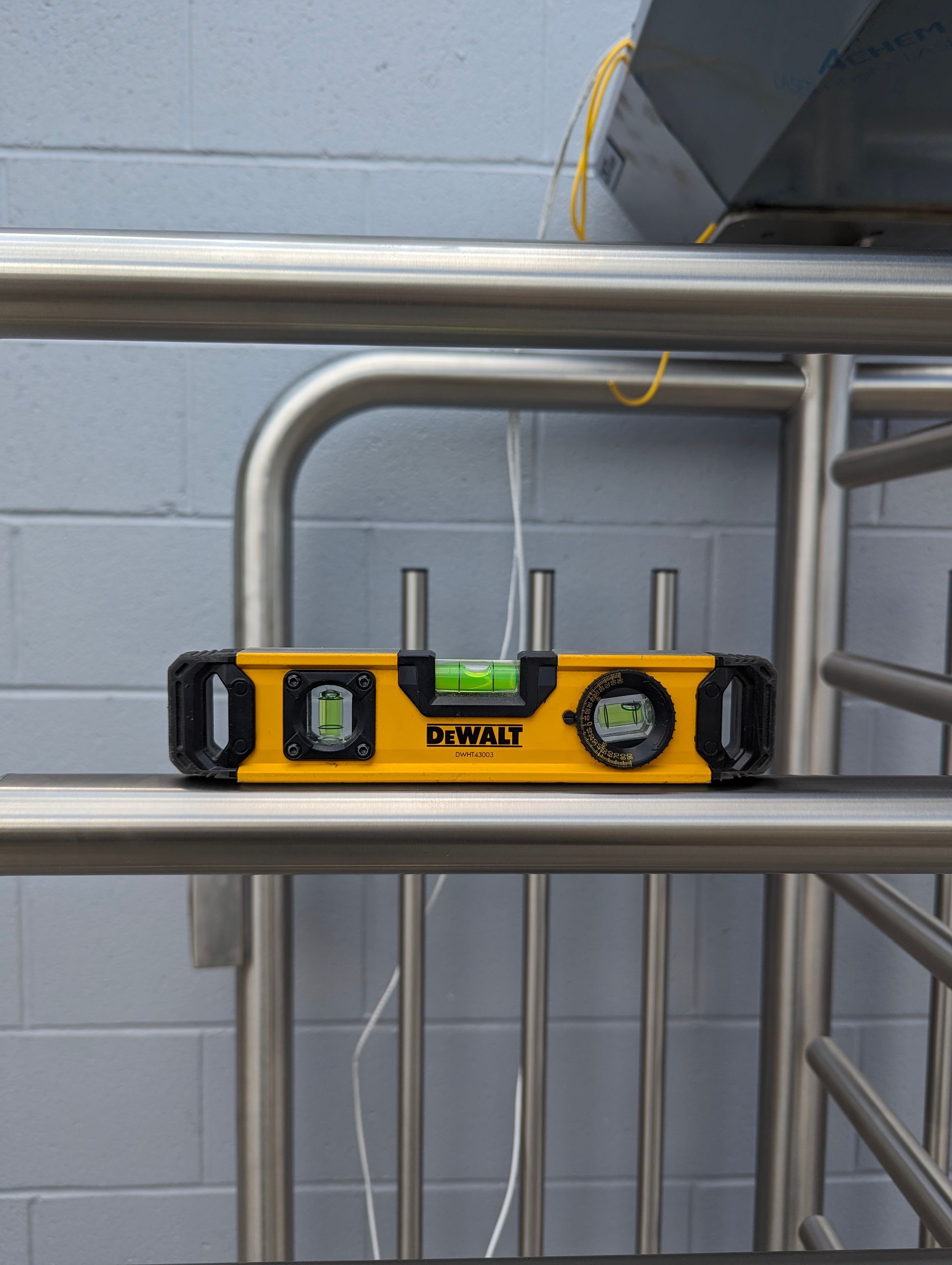 Yellow level on a silver metal bar, checking for levelness. 