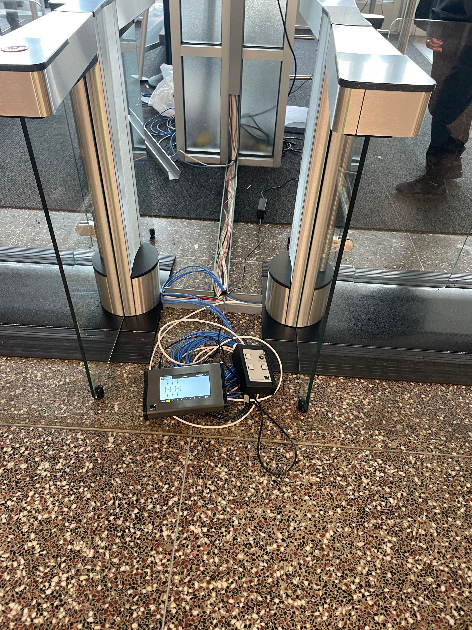 Turnstile with a connected device on the ground with wires.