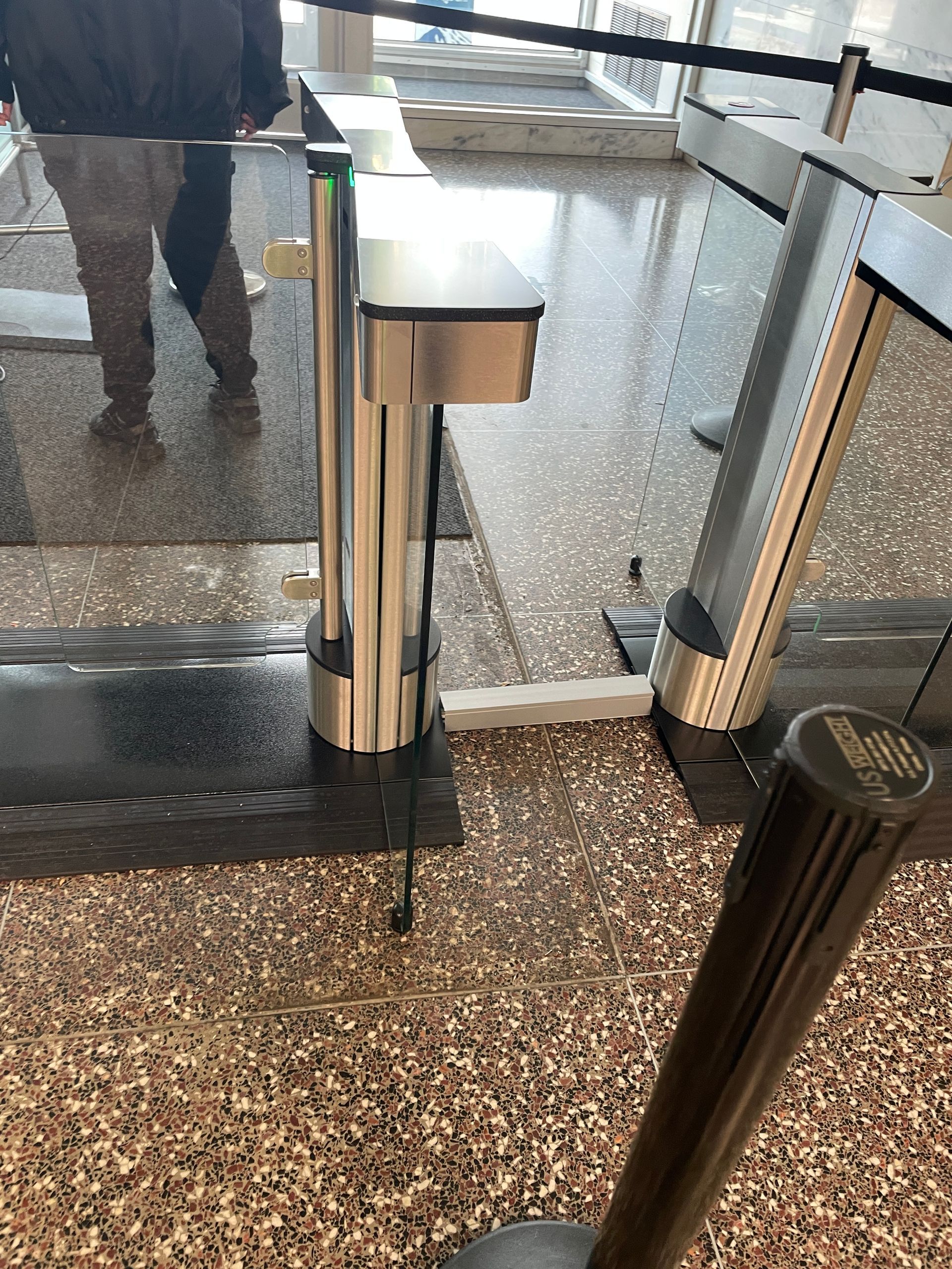 Security turnstile with a person walking past it.