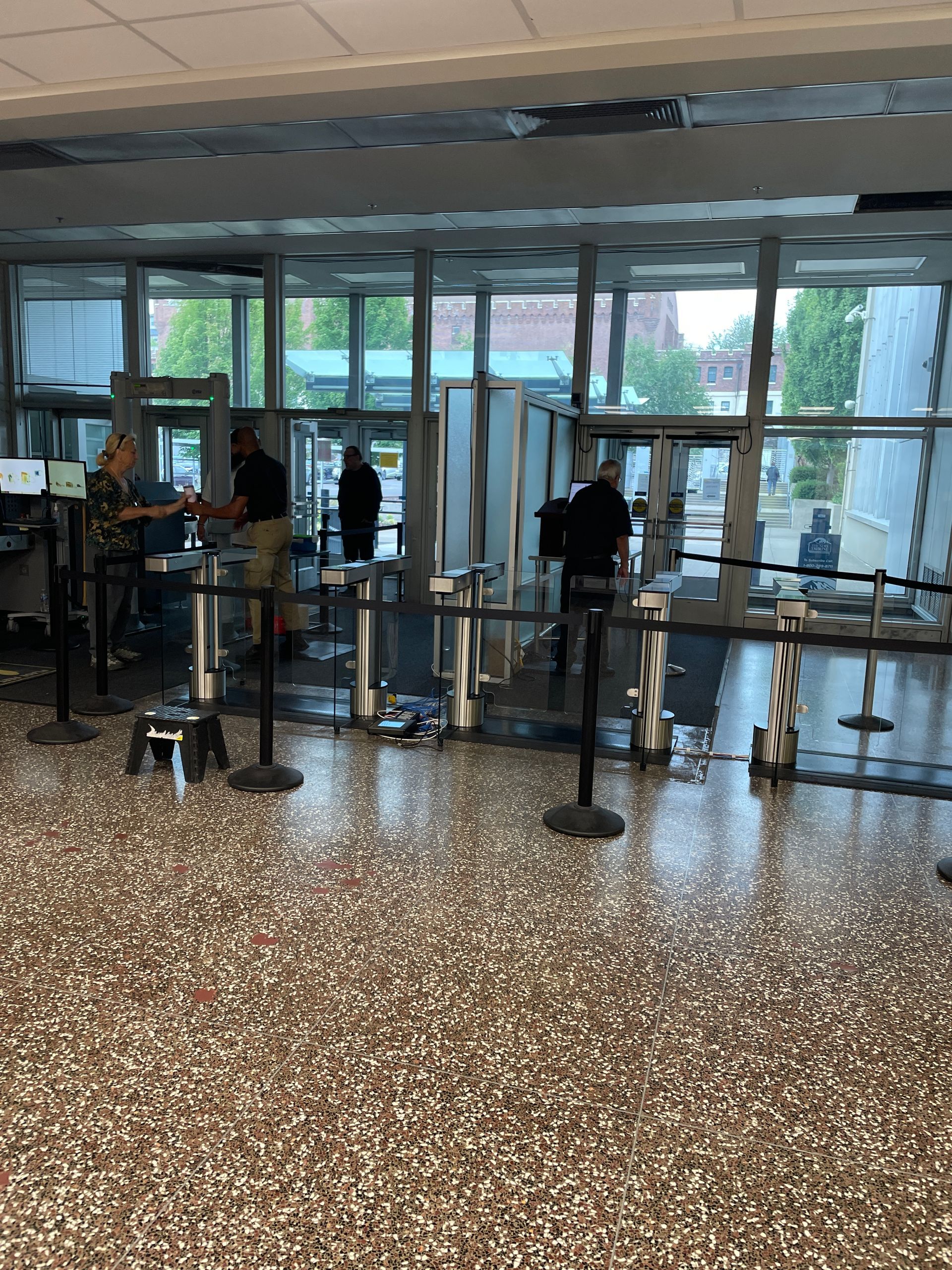 Airport security checkpoint with people going through metal detectors.
