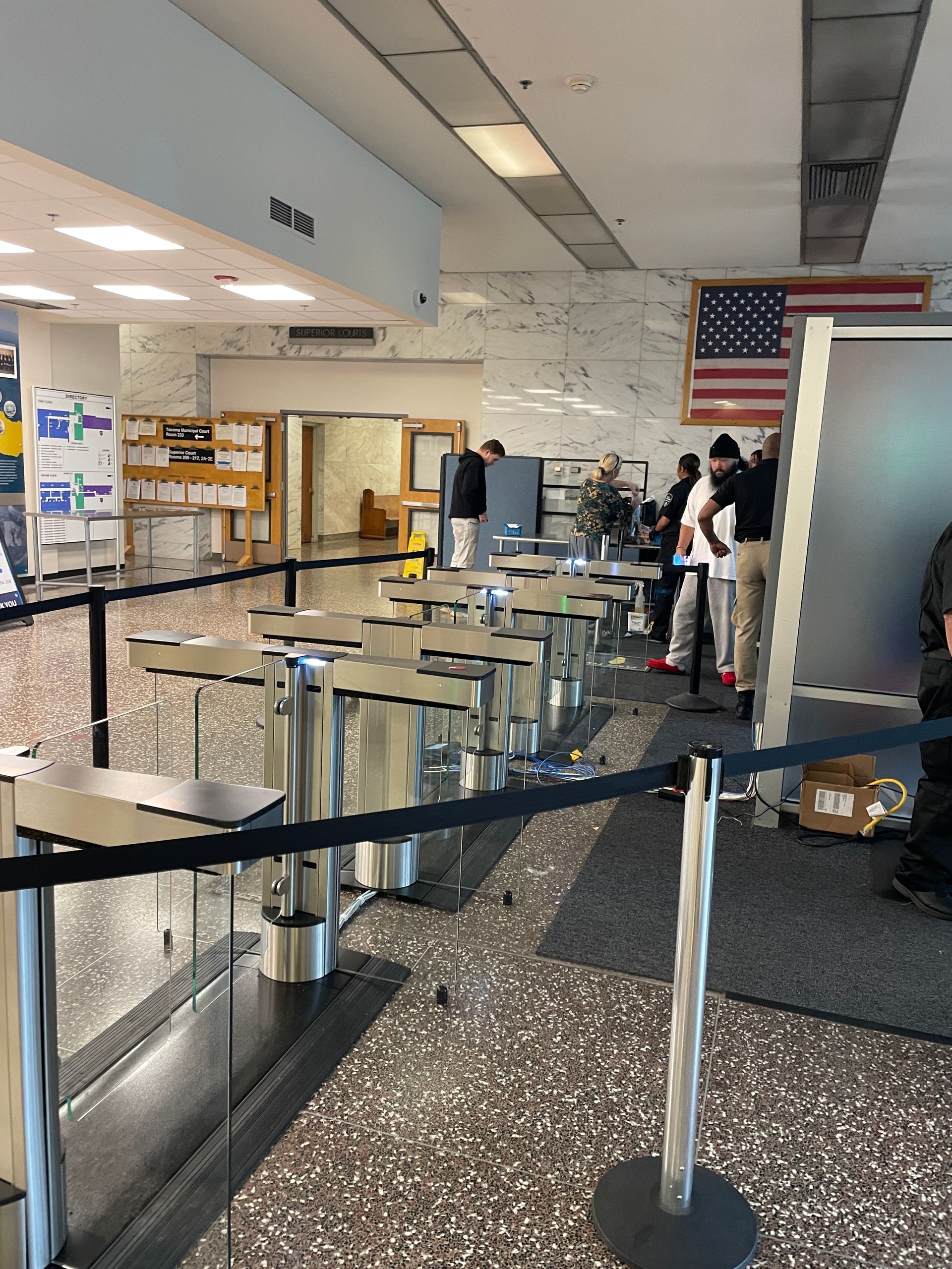 People waiting in line at a counter with stanchions. 