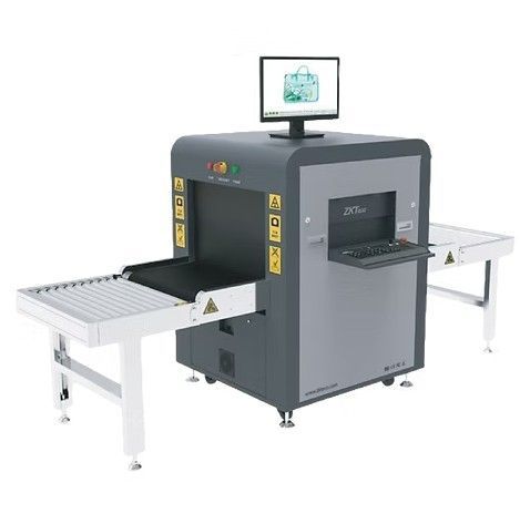 X-ray baggage scanner with conveyor belts and monitor displaying scanned bag contents.
