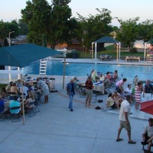 A group of people are gathered around a swimming pool