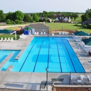 A large swimming pool surrounded by chairs and umbrellas