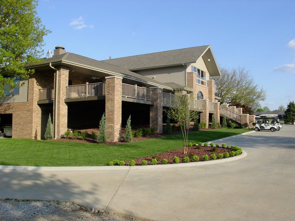 A large house with a golf cart parked in front of it