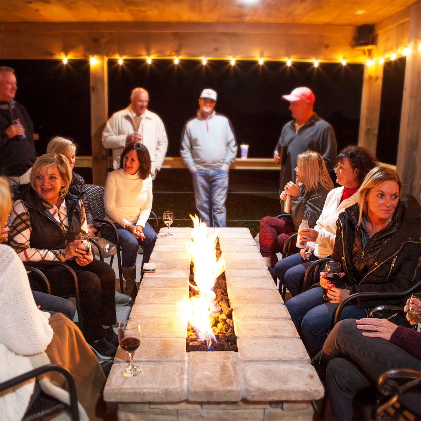 A group of people are sitting around a fire pit