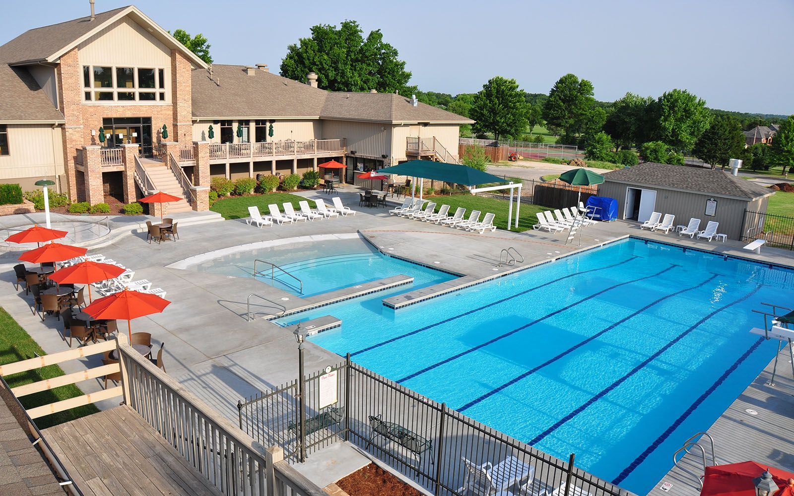 An aerial view of a large swimming pool surrounded by chairs and umbrellas