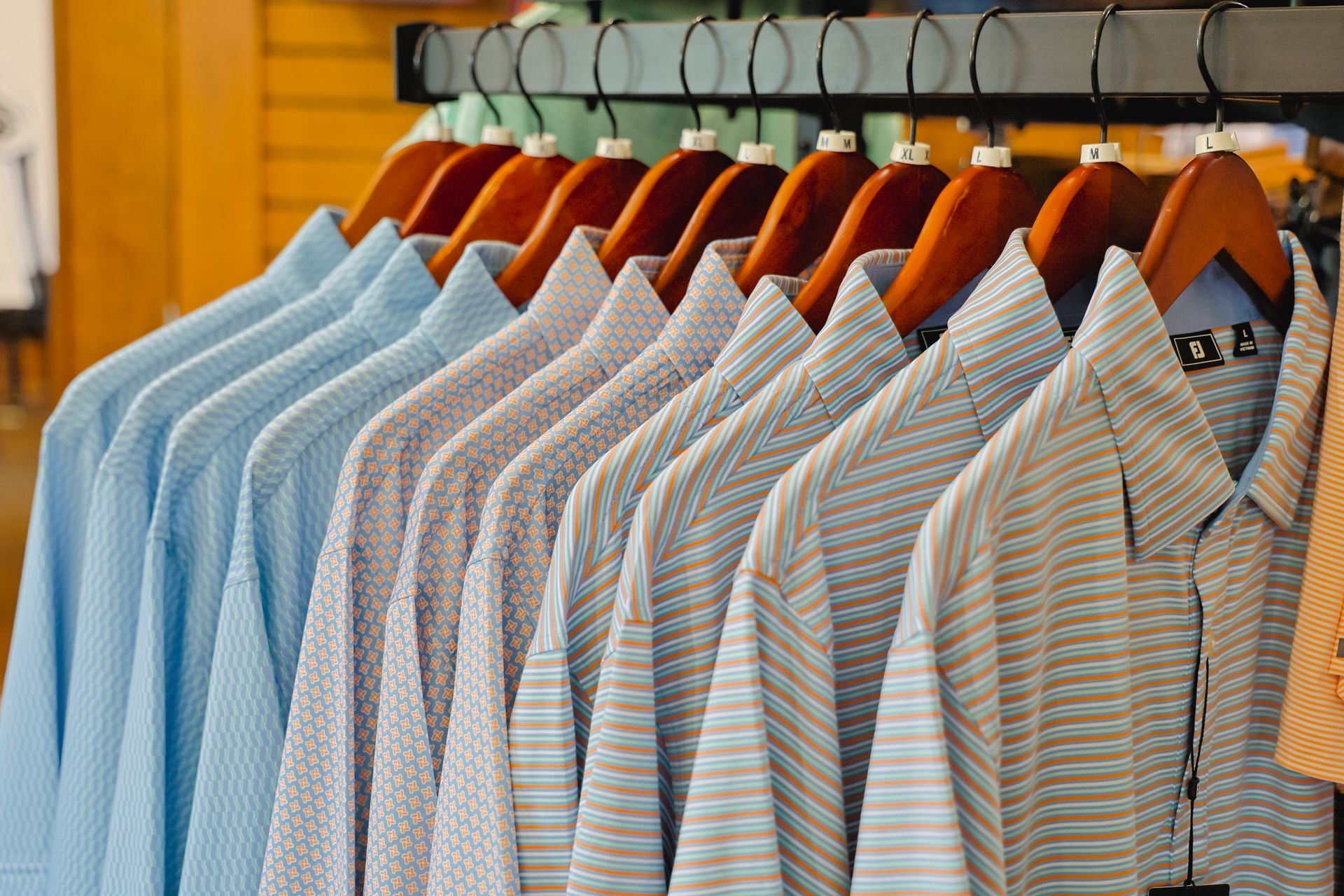 A row of shirts hanging on a rack in a store