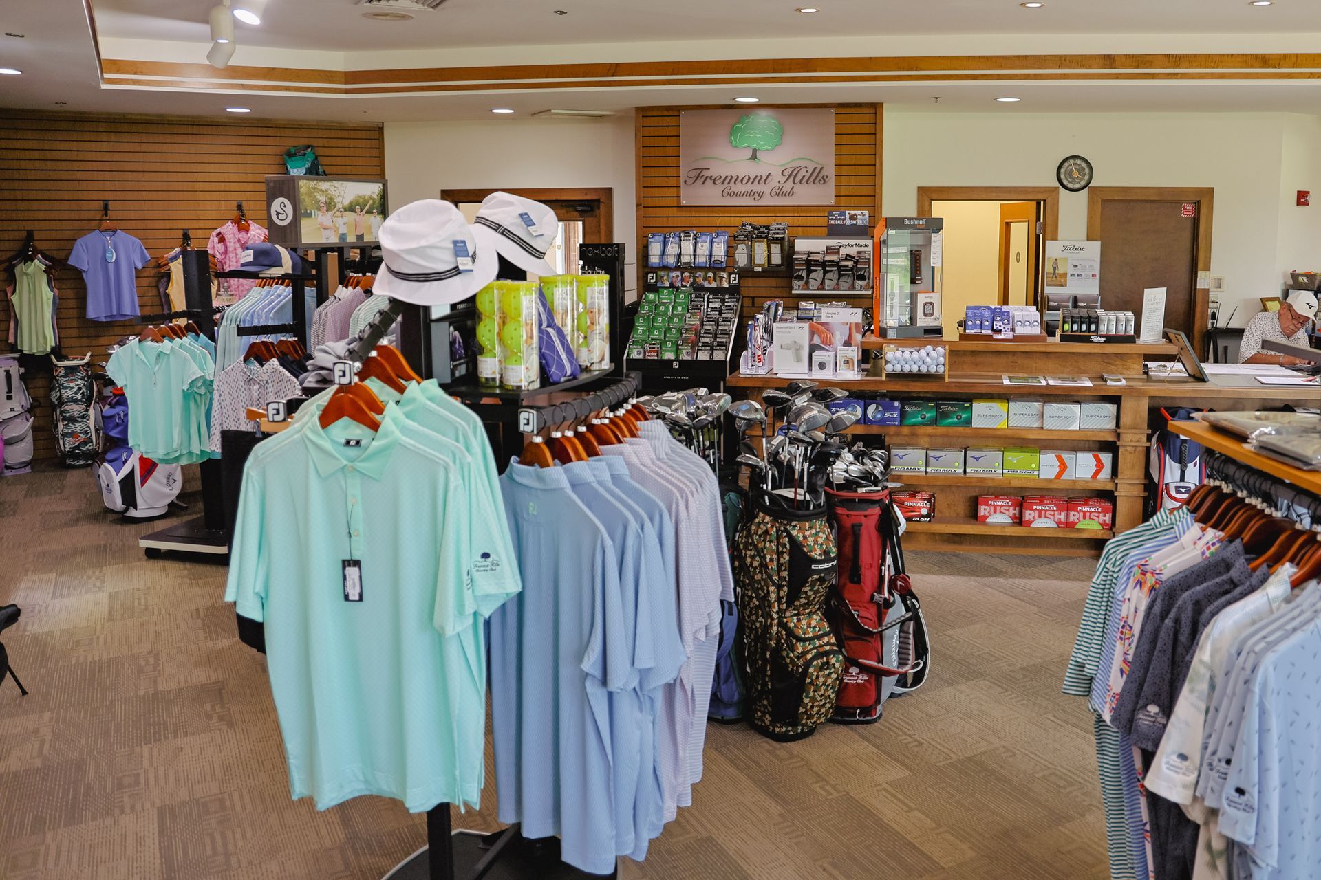 A store filled with lots of clothes and golf bags.