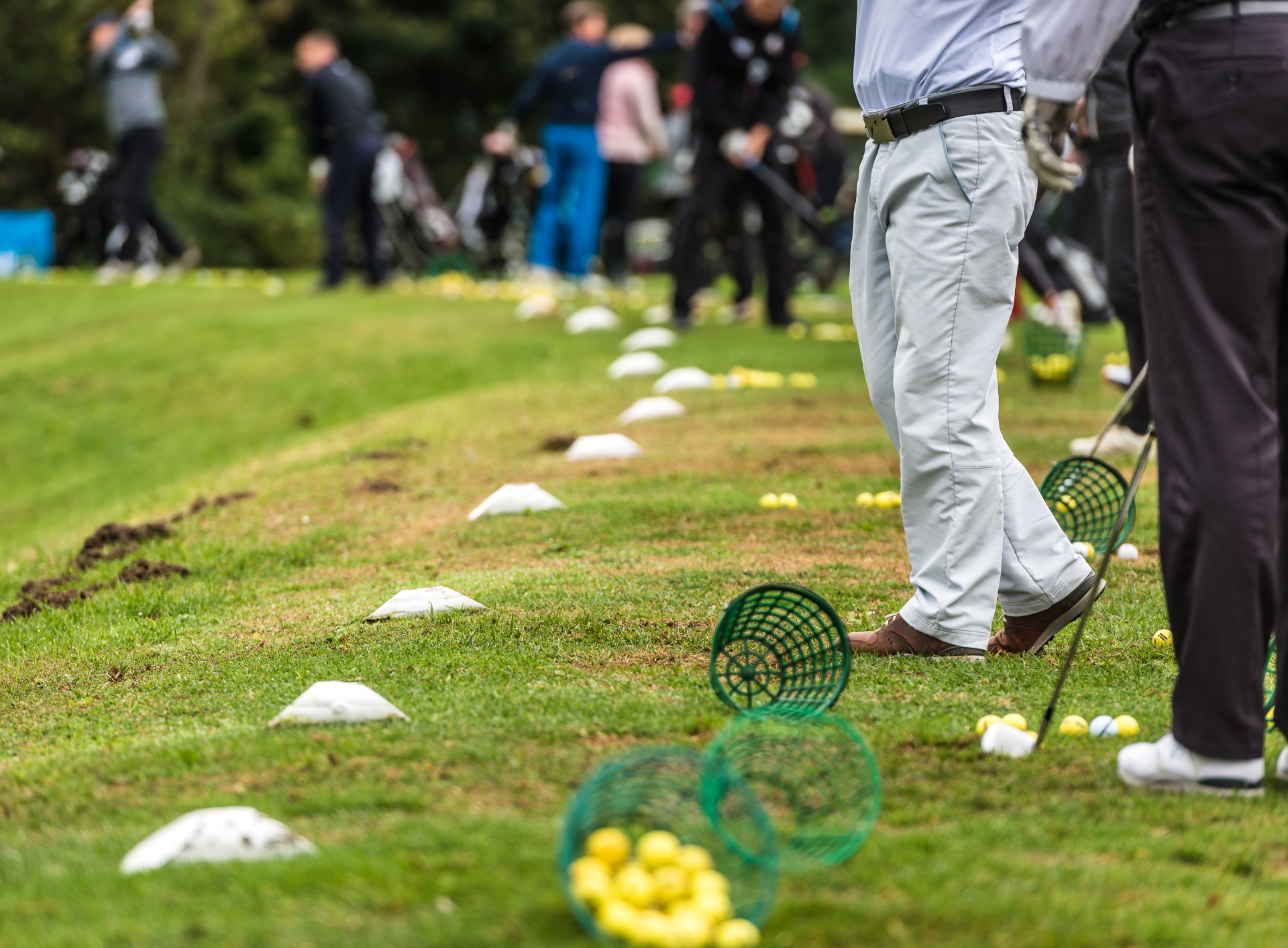 A group of people are practicing golf on a golf course.
