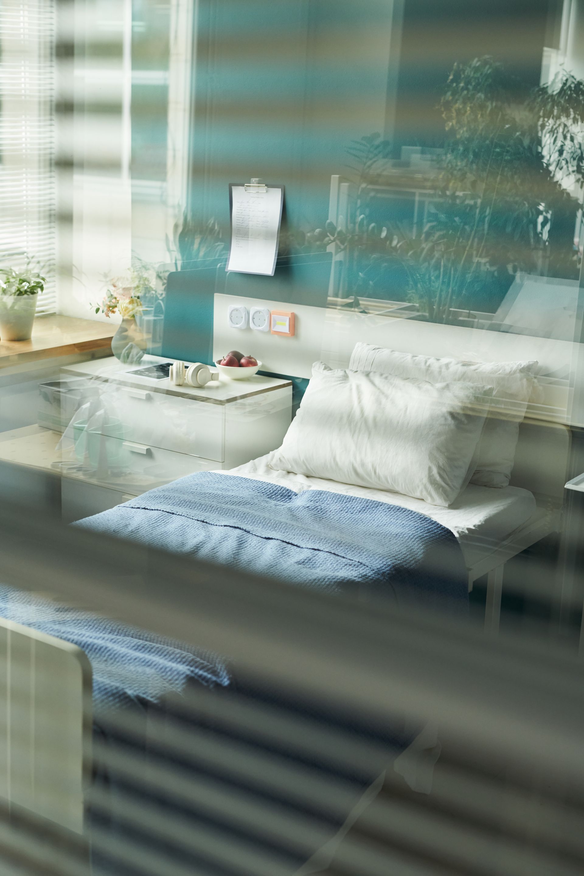 Family walking on a sidewalk, holding hands. Man, woman, and two children. Building background.