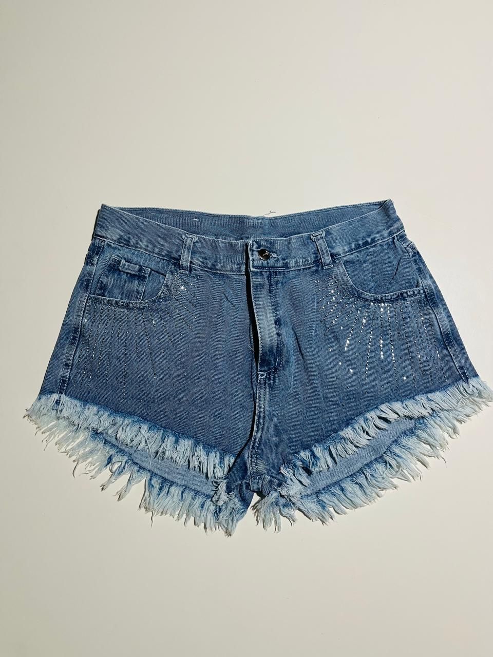 Pantalones cortos vaqueros azules con bordes deshilachados y salpicaduras de pintura.