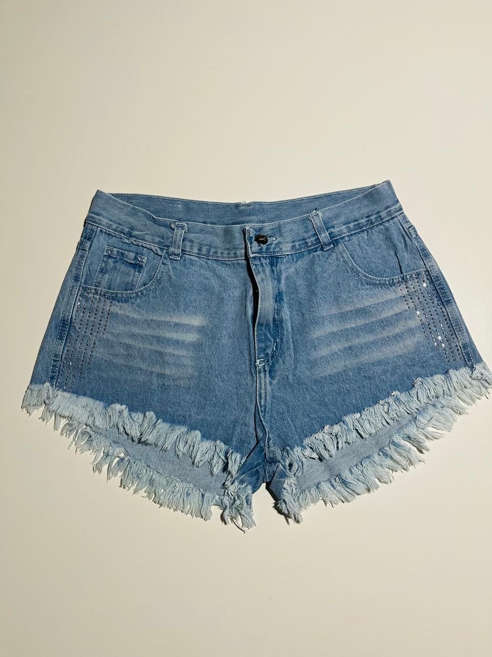 Pantalones cortos vaqueros azul claro con bajo deshilachado.