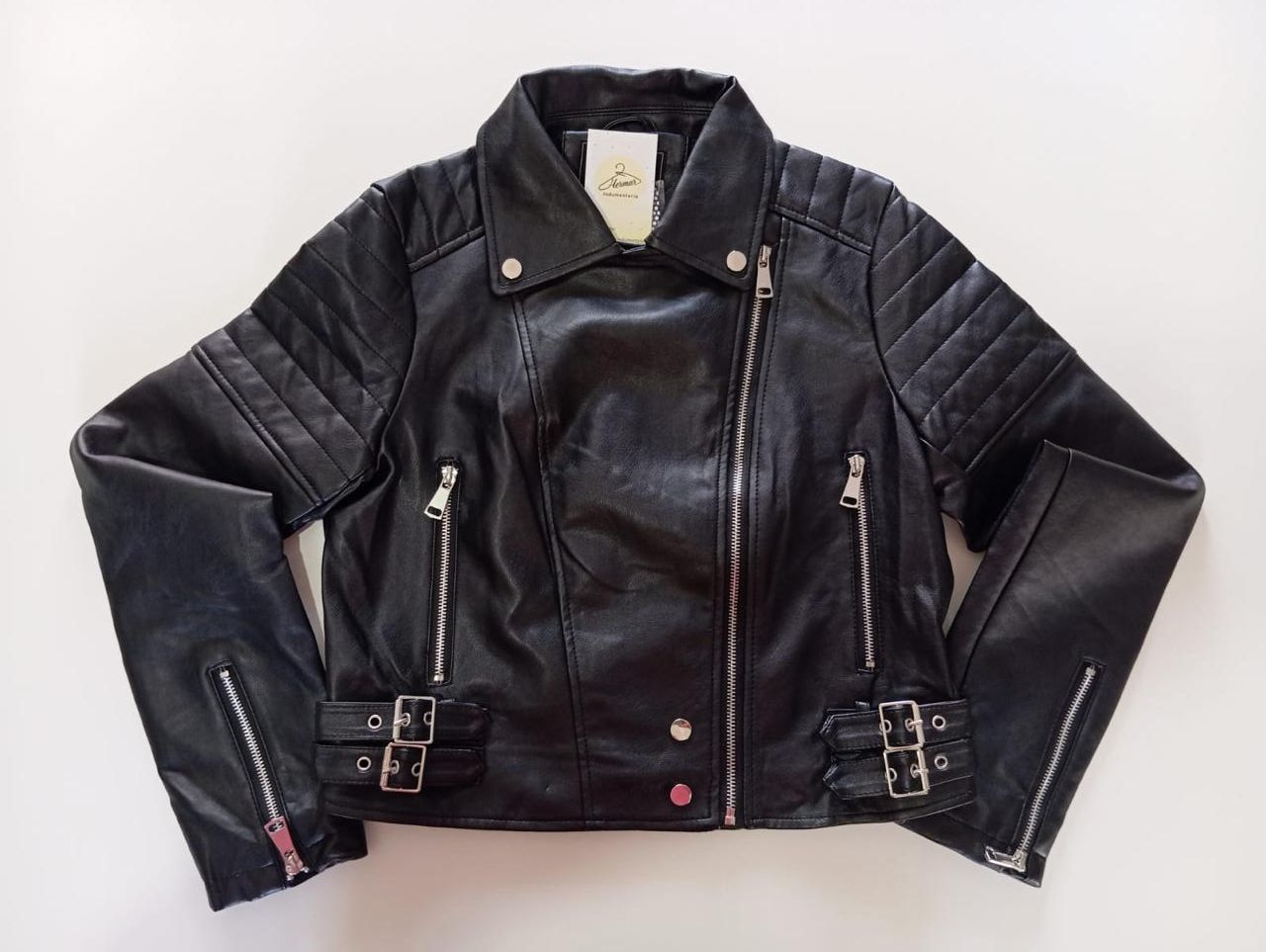 Chaqueta de cuero negra estilo motero con cremalleras y hebillas plateadas.