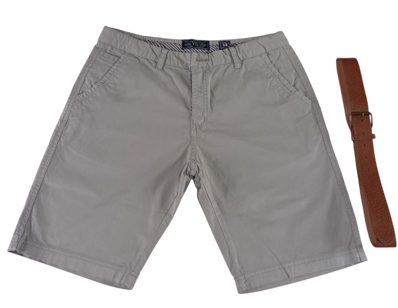 Tres pares de pantalones cortos en tonos verde, gris y negro, apilados sobre una superficie blanca.