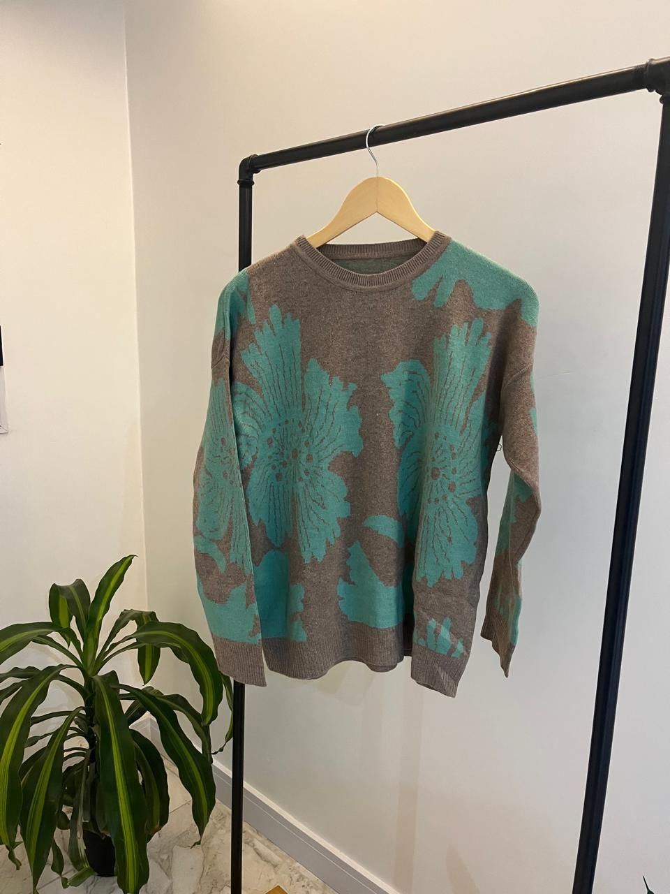 Perchero con varios jerseys: negro con corazón rosa, celeste, blanco y otros.