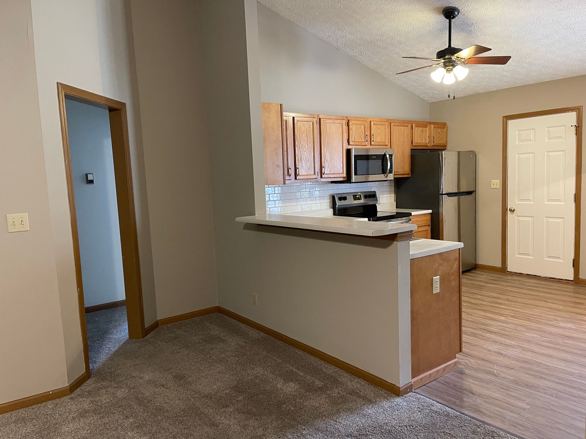 a kitchen with a ceiling fan and a refrigerator in a house .