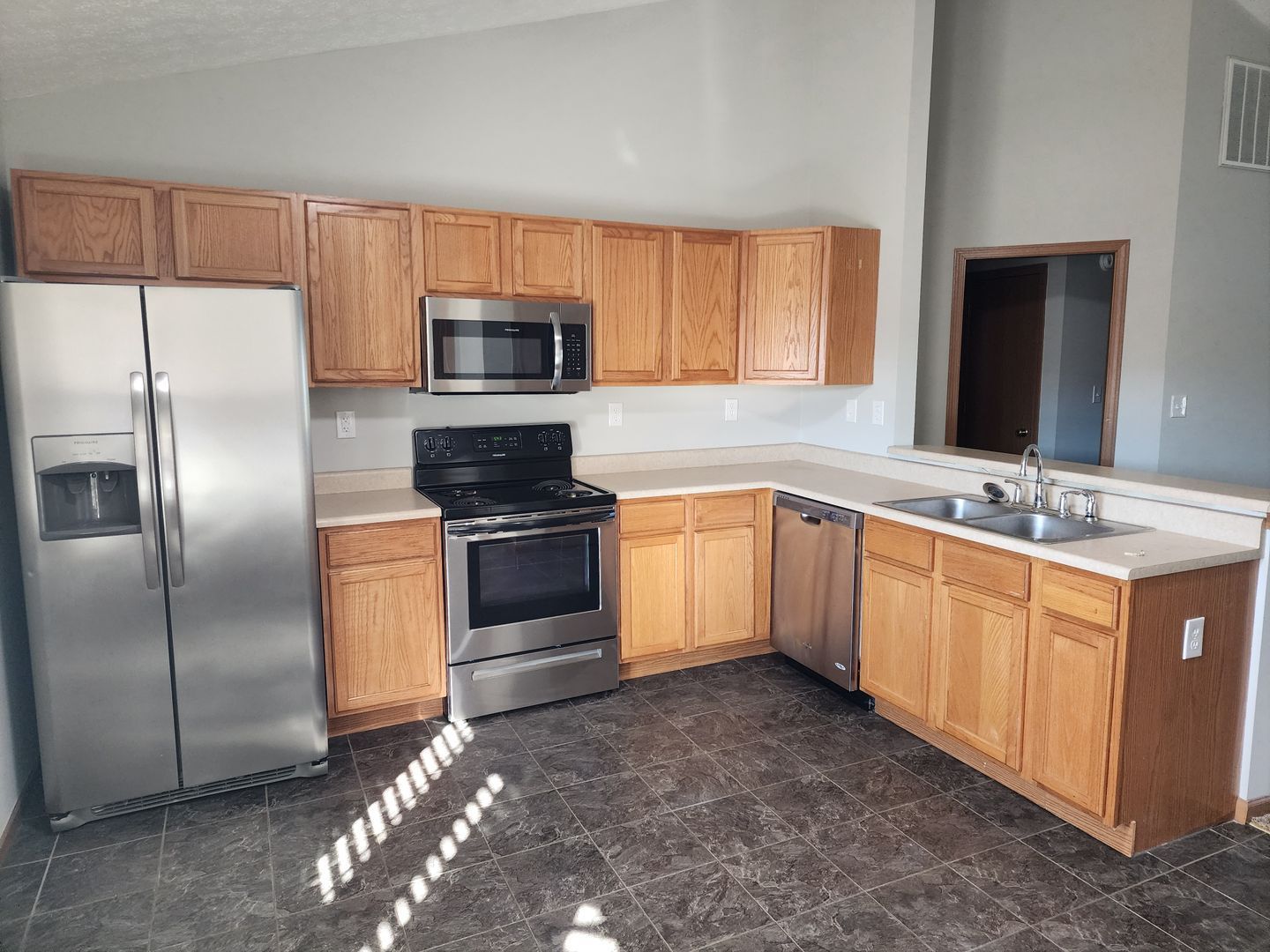 a kitchen with stainless steel appliances and wooden cabinets