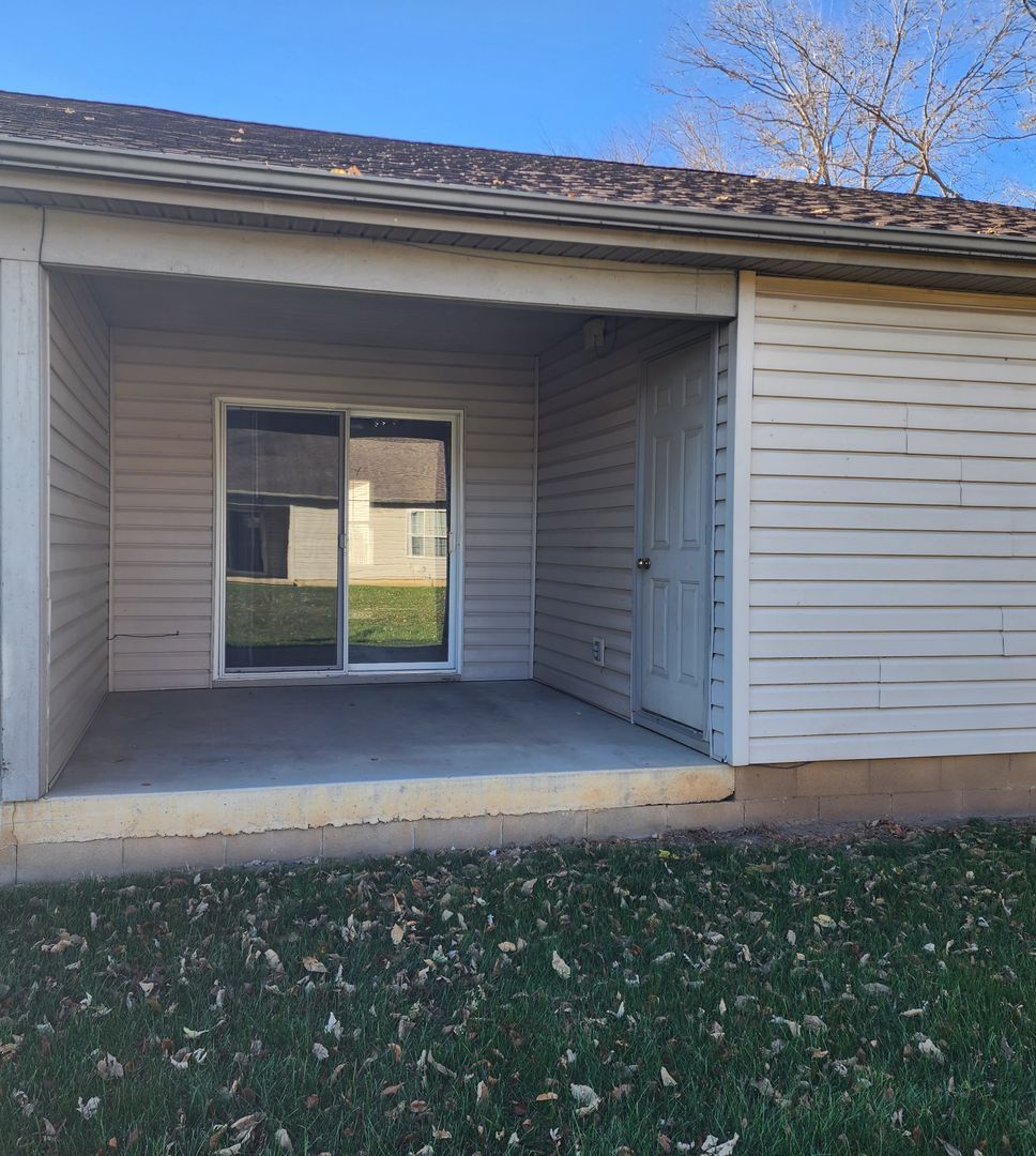 a small house with a porch and a sliding glass door .