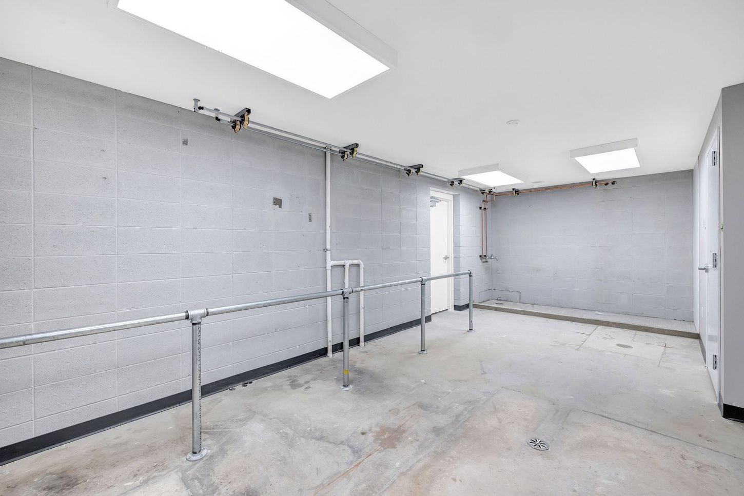 An empty room with a concrete floor and a metal railing.