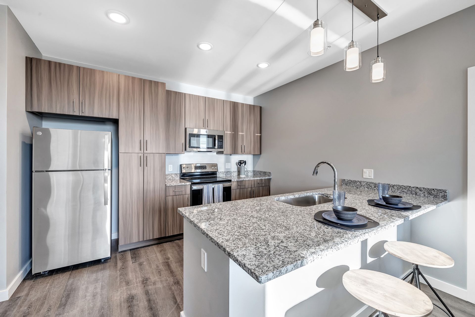 A kitchen with granite counter tops , stainless steel appliances , and wooden cabinets.