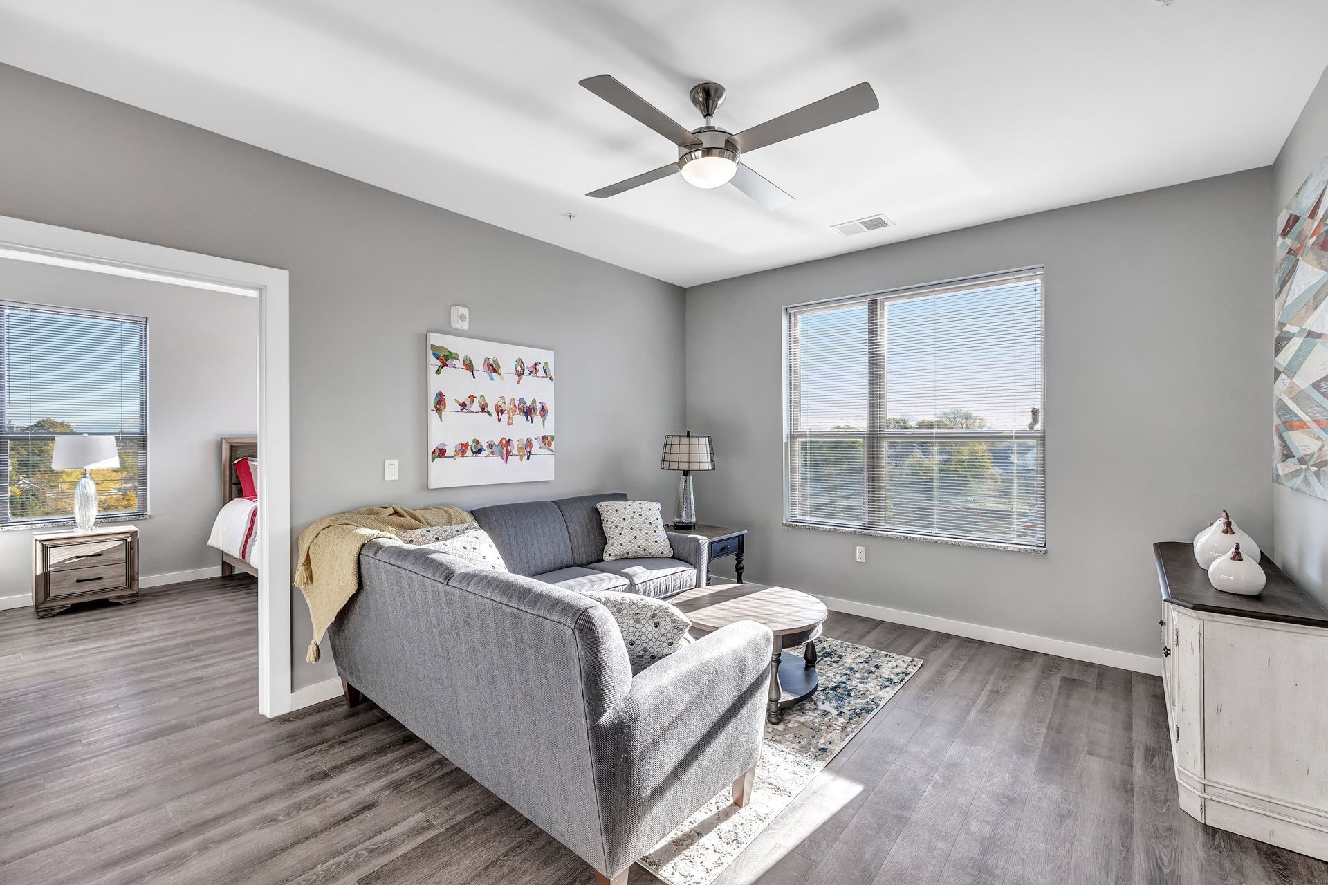 A living room with a couch and a ceiling fan.