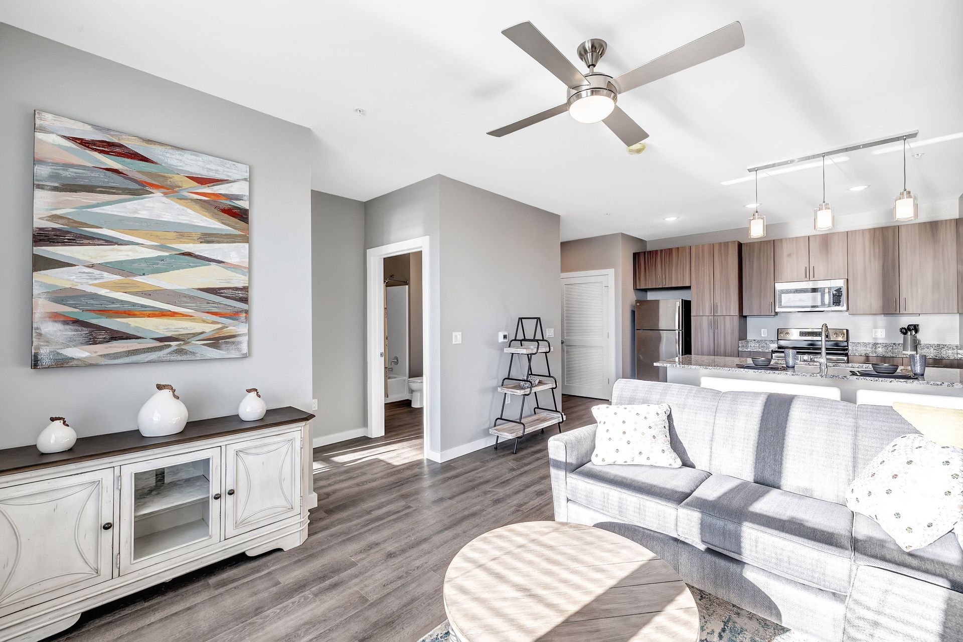 A living room with a couch , table , and ceiling fan.
