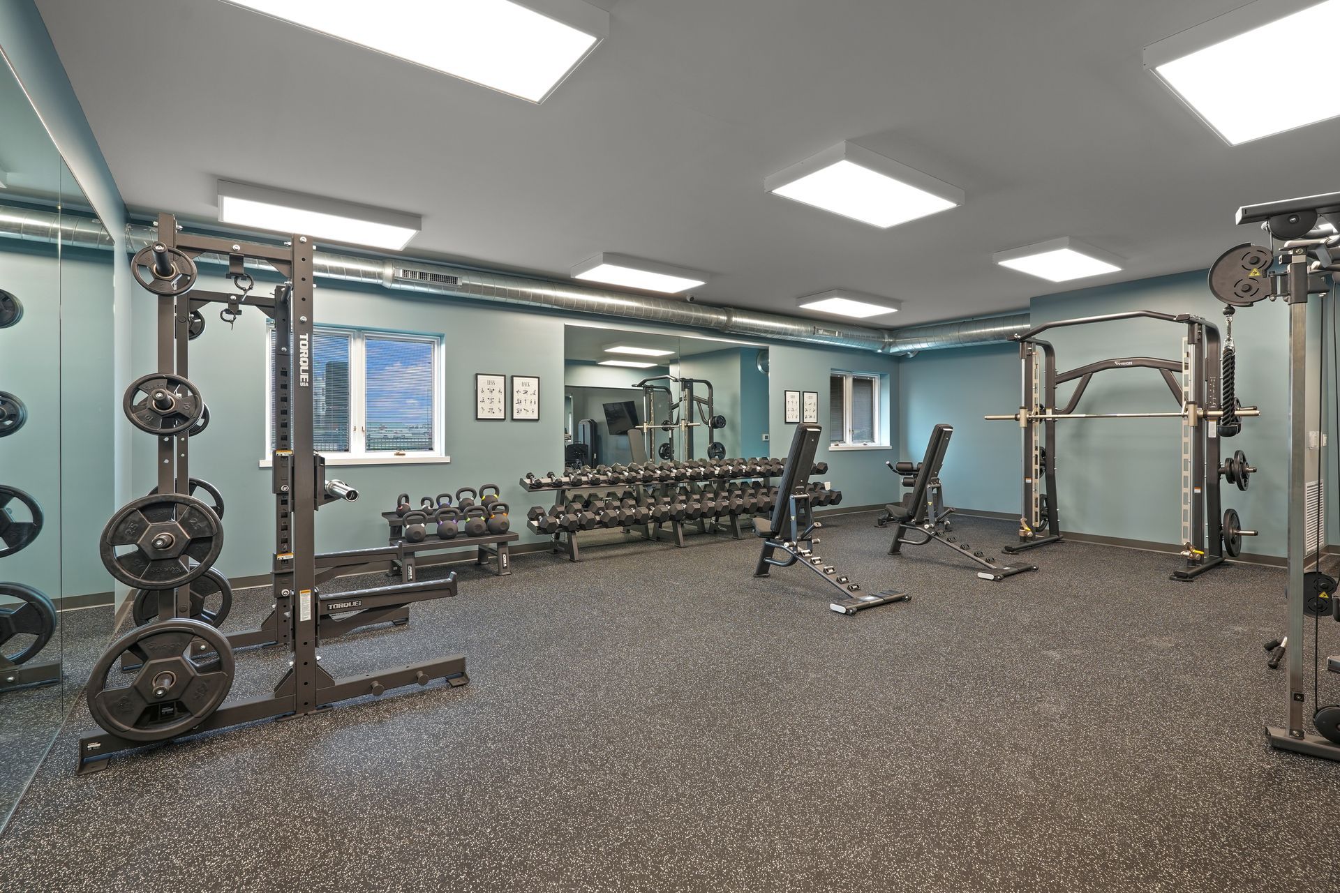 A gym with a lot of equipment and a large mirror