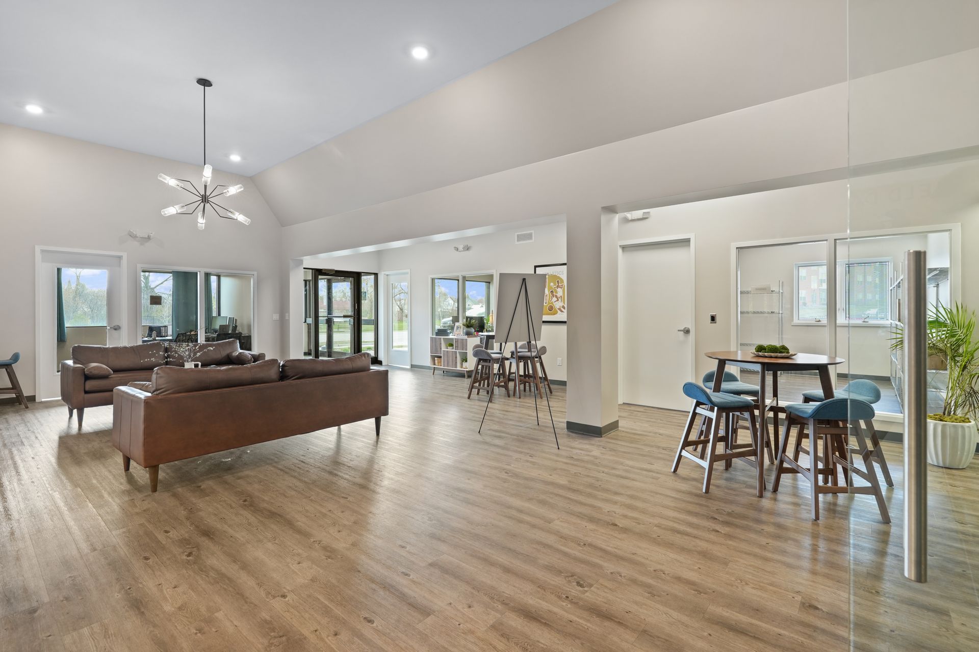A living room with hardwood floors , a couch , a table and chairs.