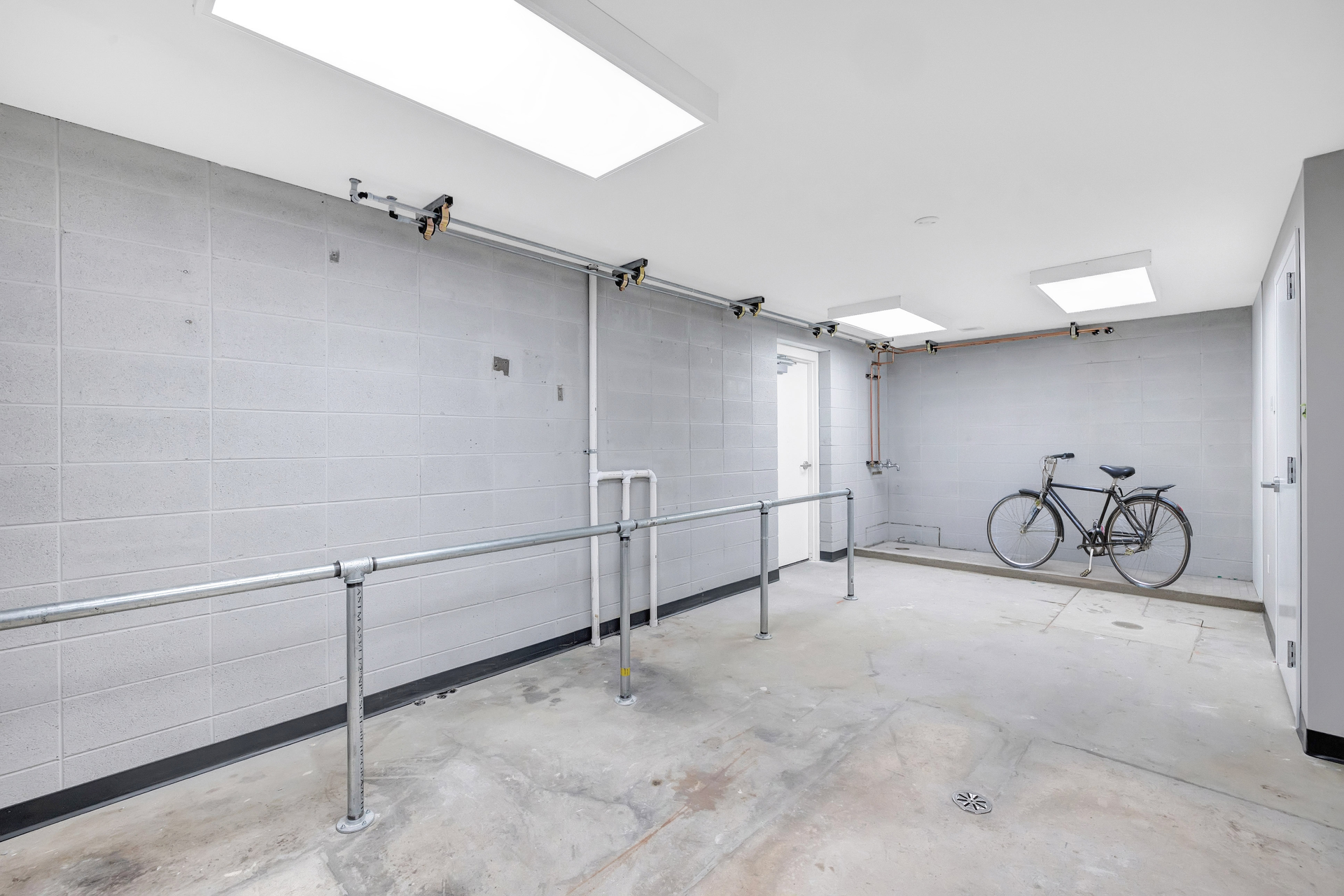 A bicycle is parked in a garage next to a fence.