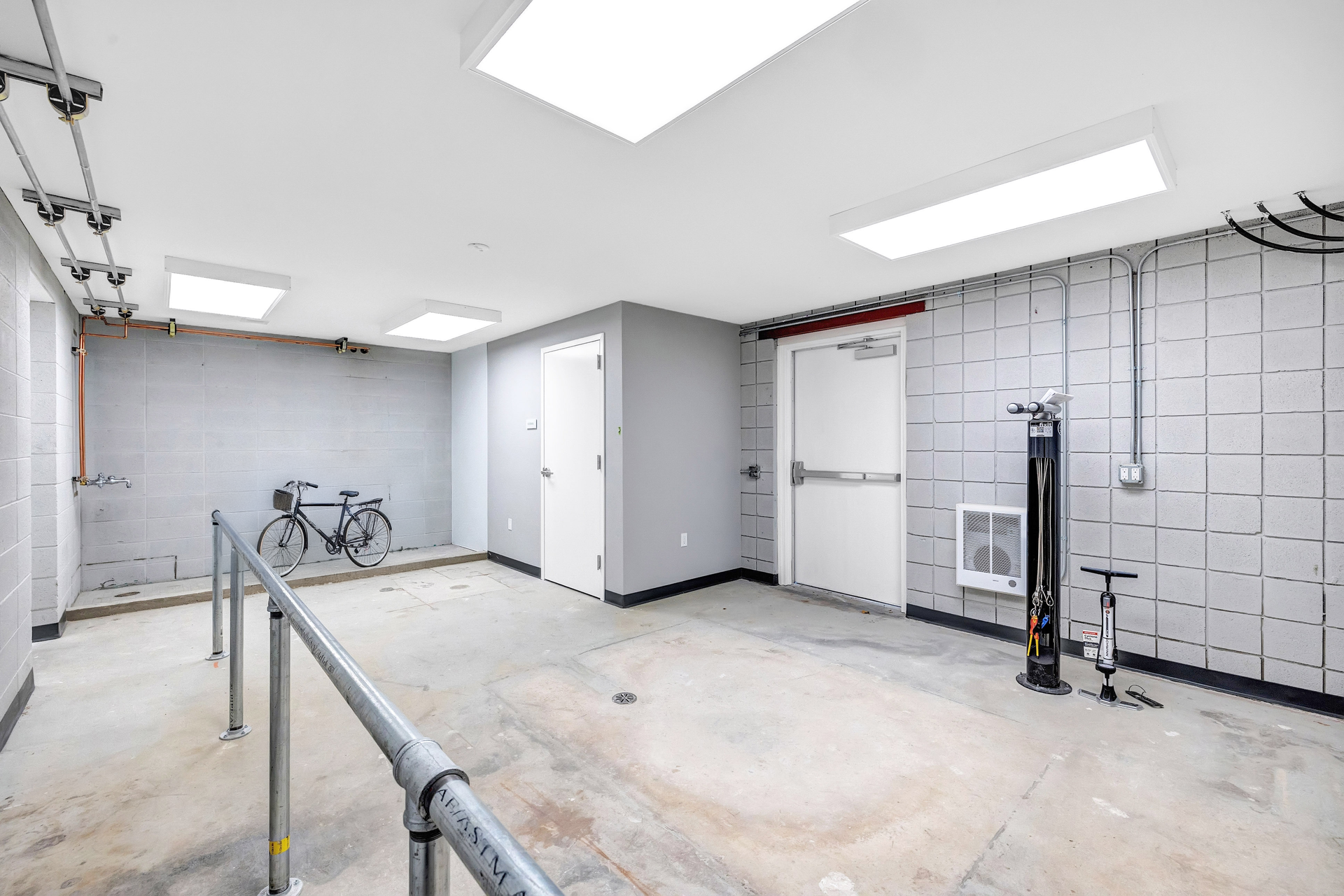 A large empty room with a bicycle parked in the corner.