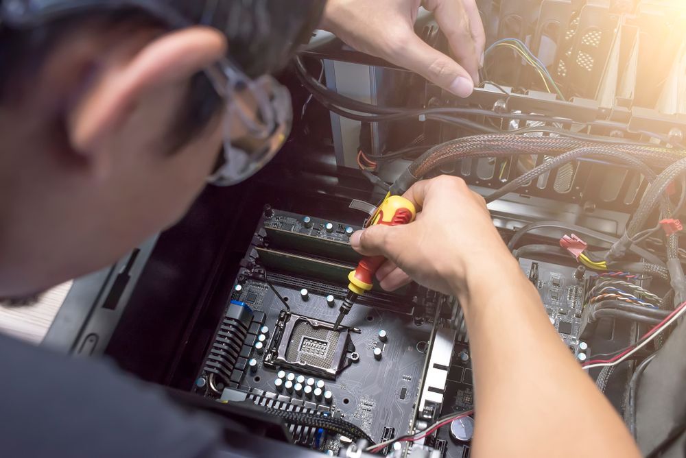 A Man Is Working On A Computer — Dateline Computers Authorised Jaycar Reseller In Proserpine, QLD