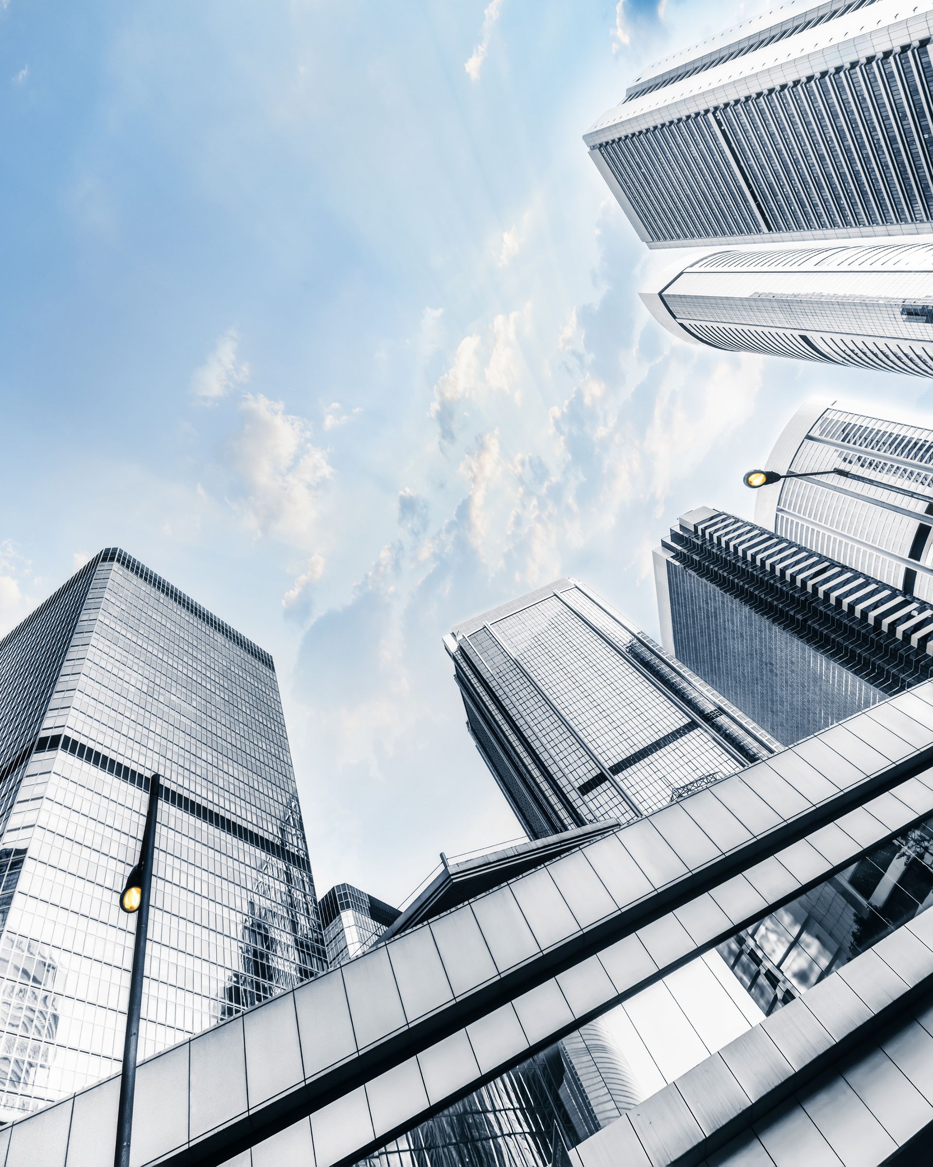 Looking up at a group of tall buildings with a blue sky in the background.
