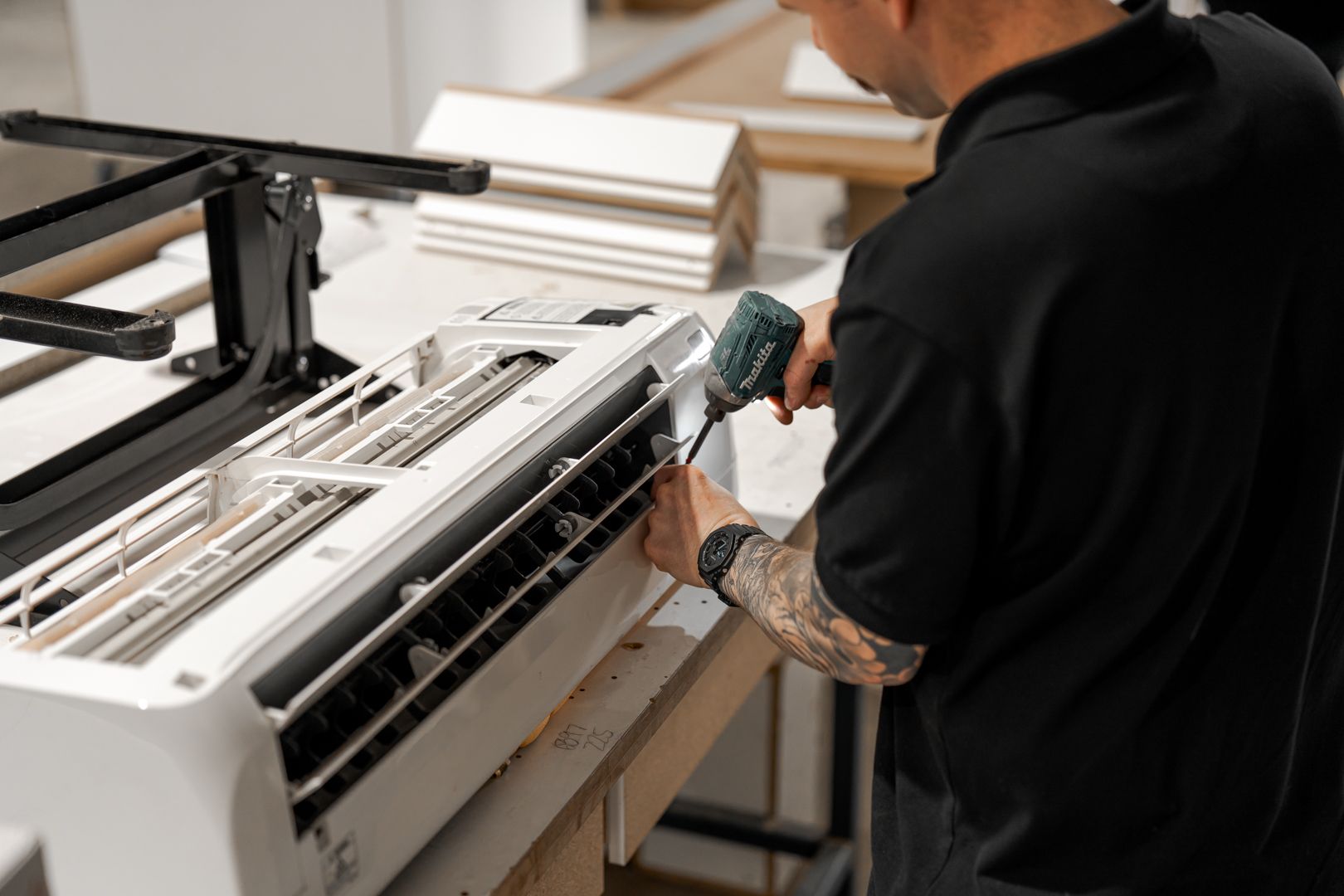 Integrated Services team member fixing air conditioning unit in Toowoomba workshop