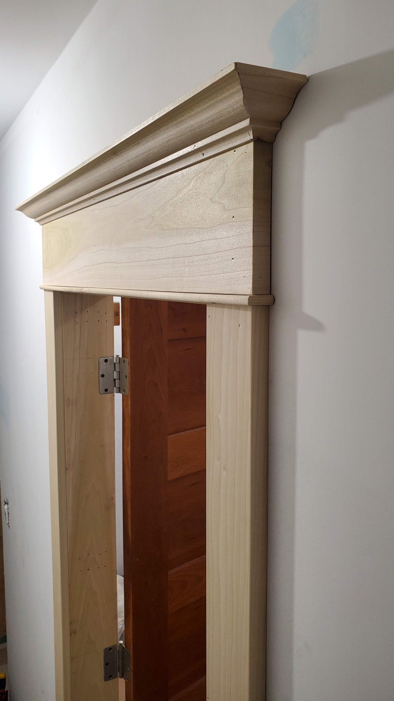 A wooden door with a molding on top of it in a room.