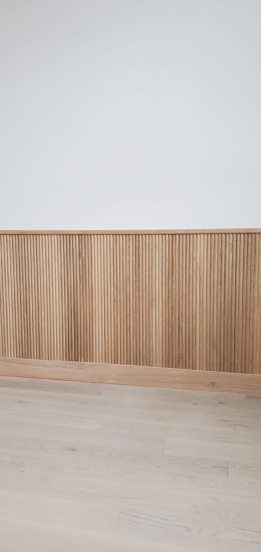 An empty room with a wooden wall and a wooden floor.