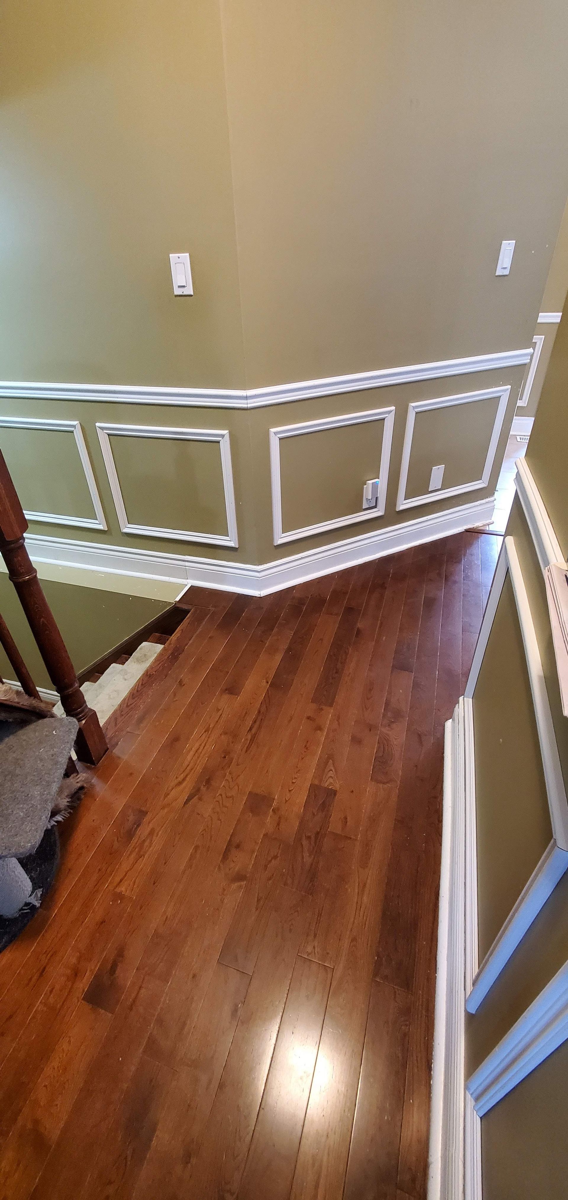 A staircase with hardwood floors and a railing in a house.