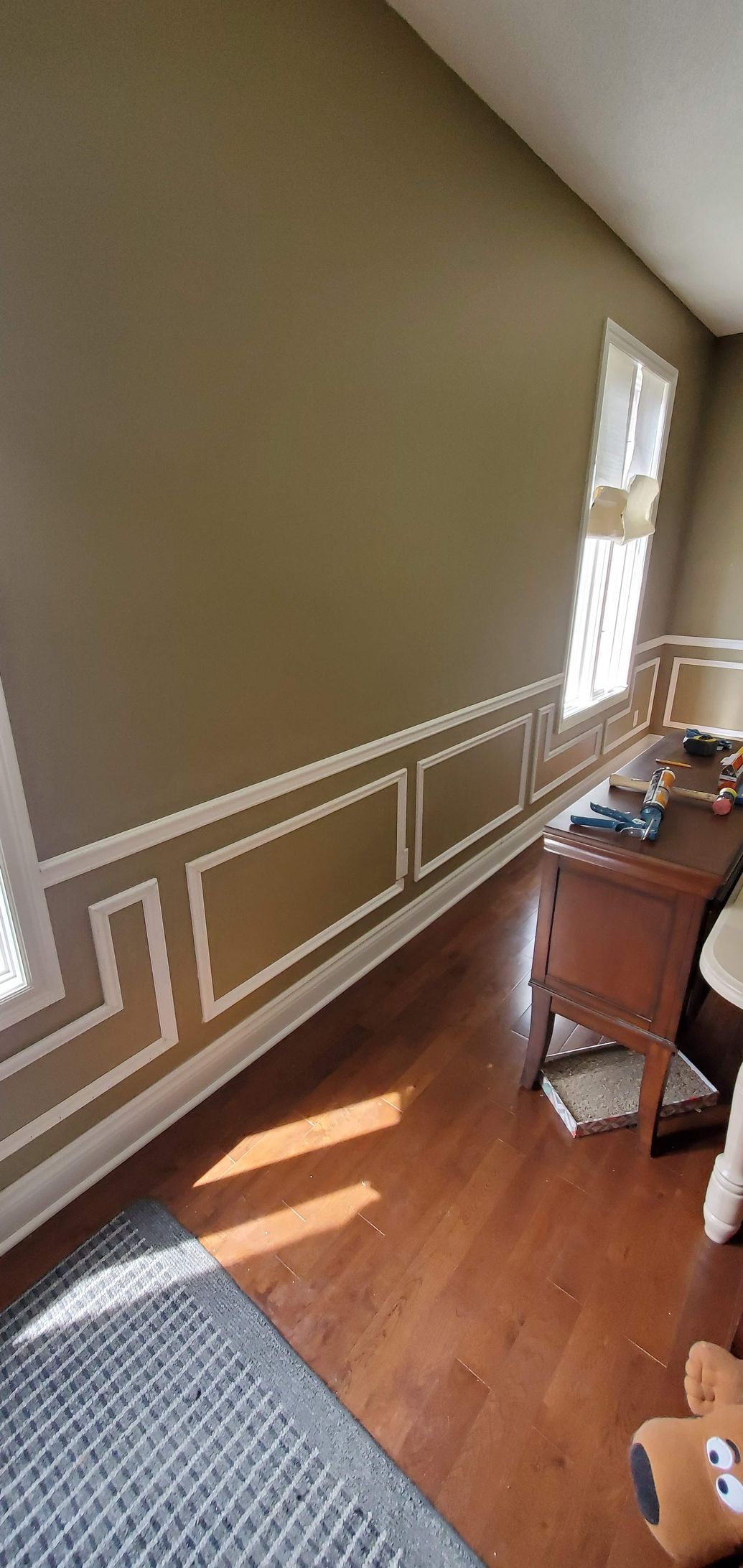 A living room with hardwood floors and a desk.