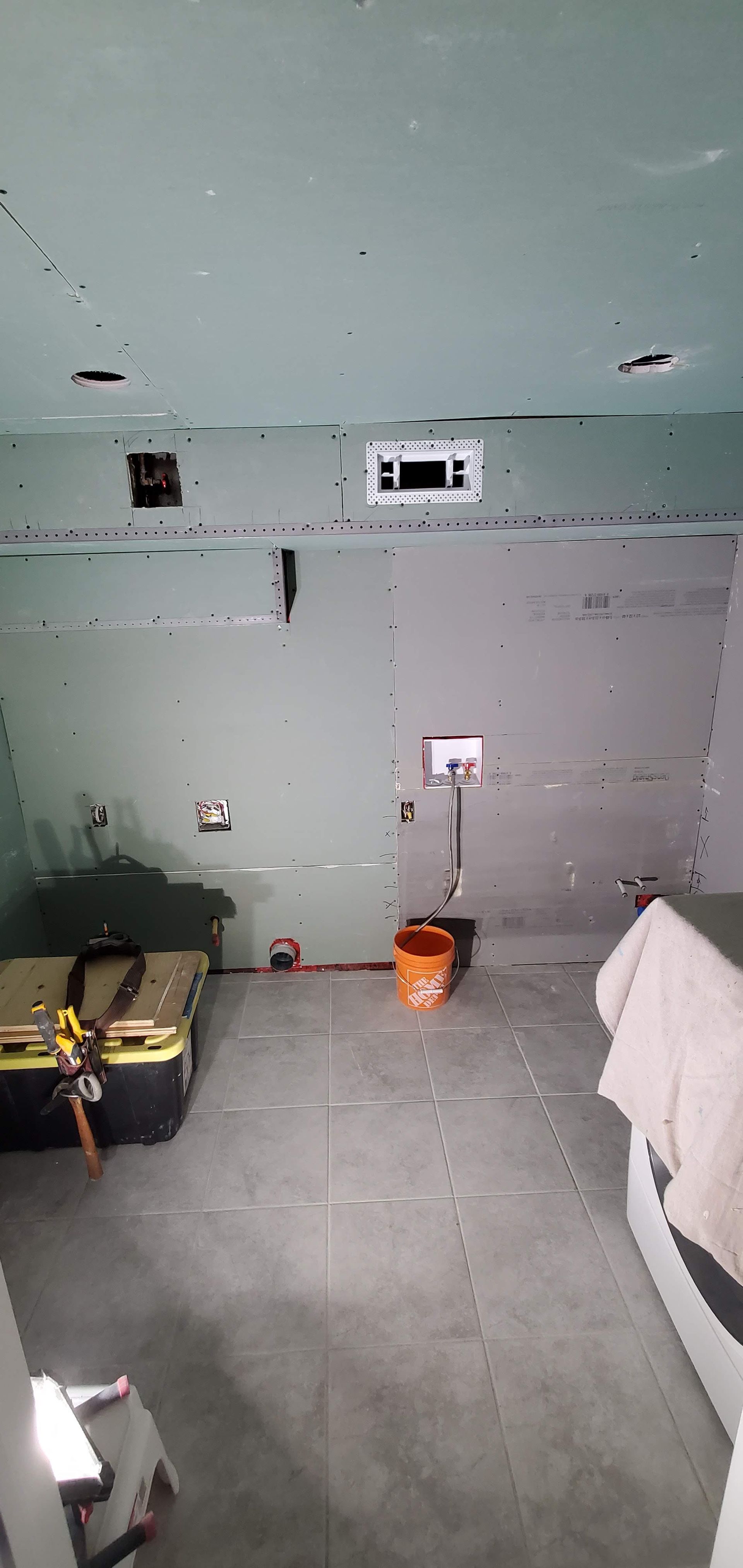 A room with a bucket and a toolbox in it.